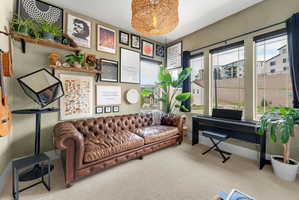 Spacious room featuring multiple large windows, wall-mounted shelving, and a natural fiber pendant light fixture