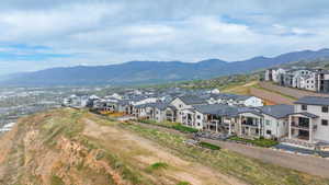 Hillside community featuring modern residences with multiple balconies and dark-pitched roofs