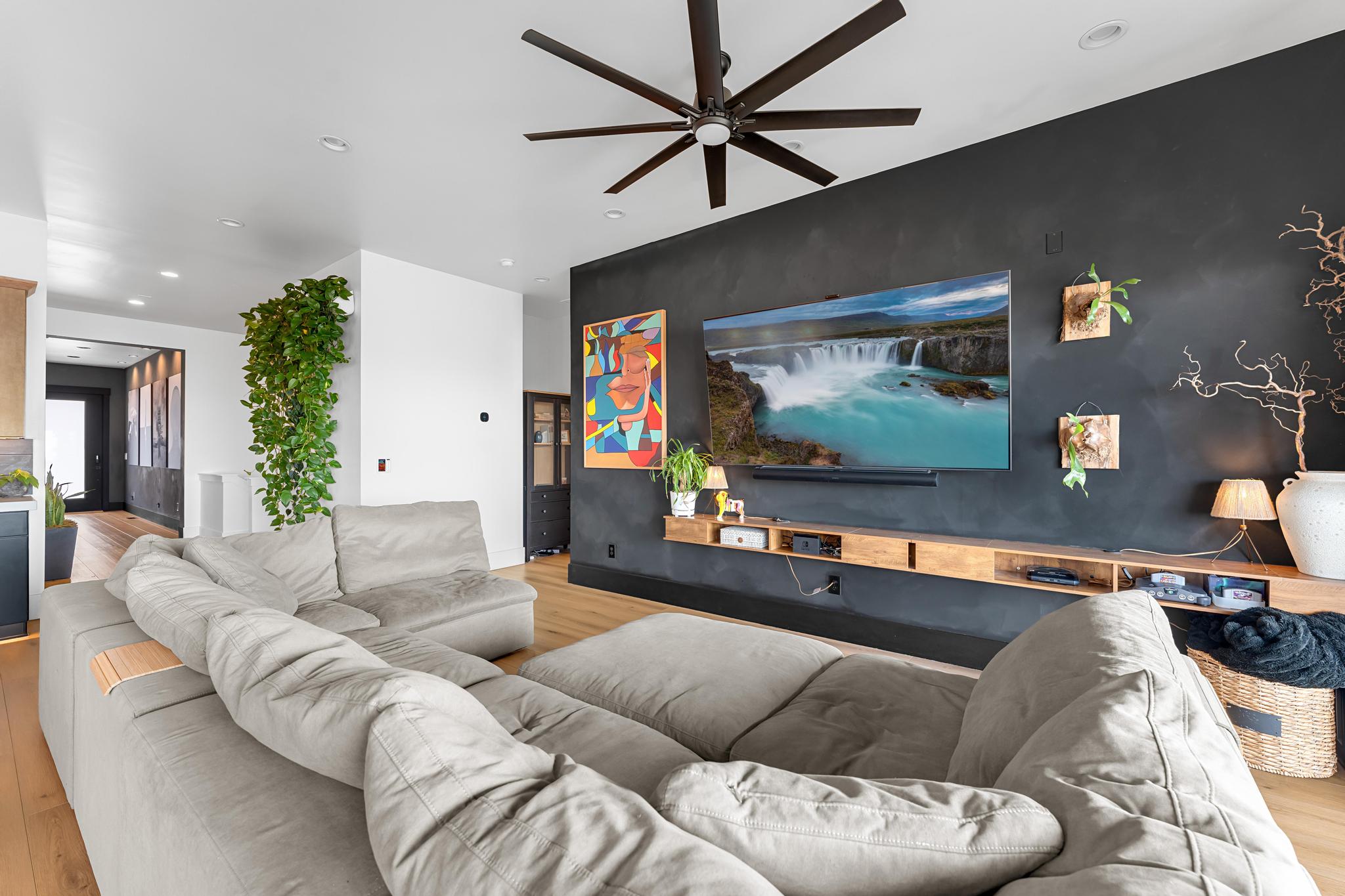 Living area featuring wood-finish flooring and a contemporary ceiling fan