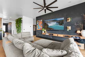 Living area featuring wood-finish flooring and a contemporary ceiling fan