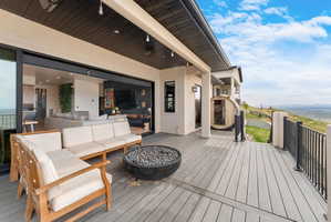 Expansive outdoor deck featuring composite decking, a built-in fire pit, and black metal railings
