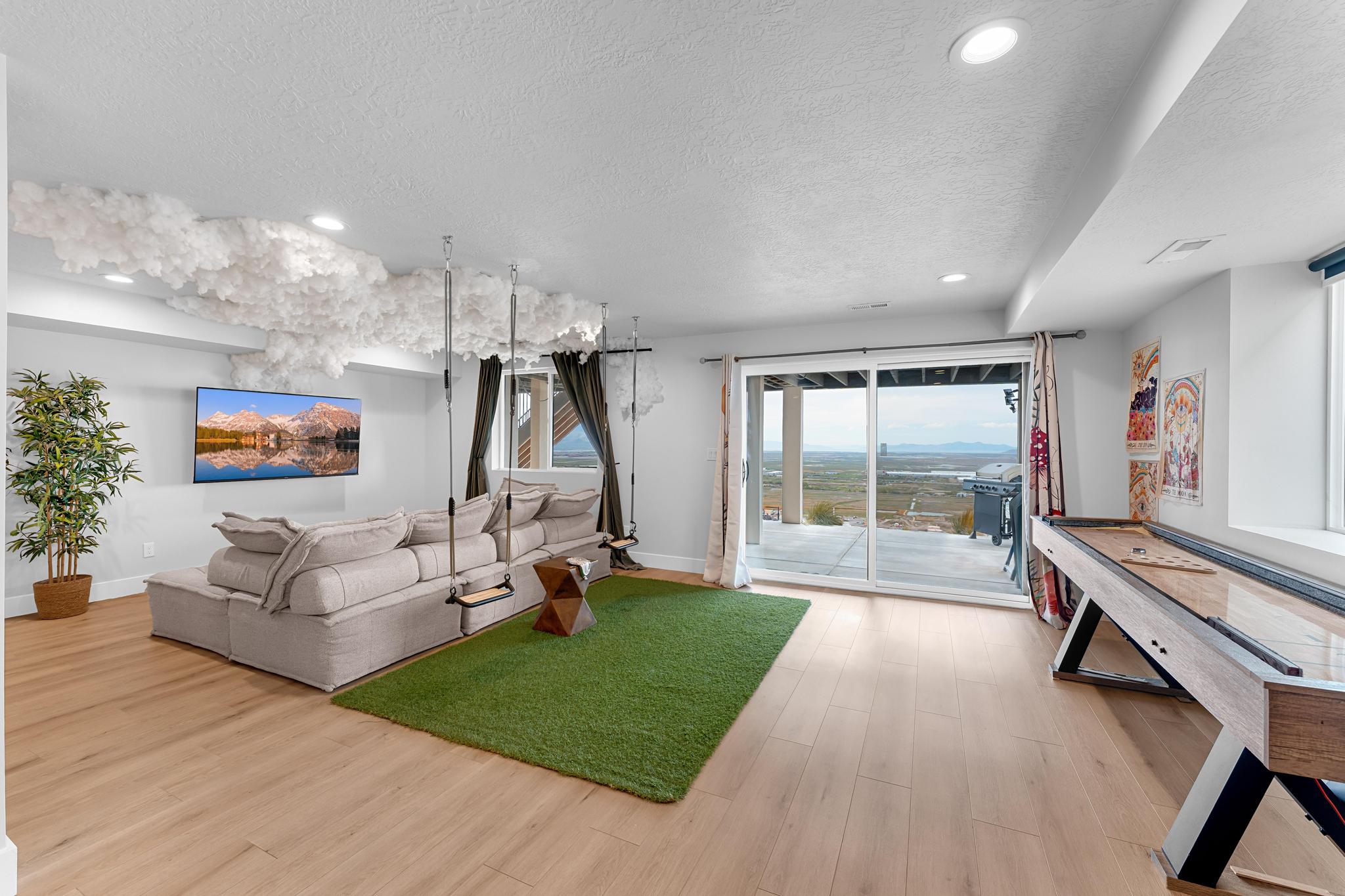 Spacious lower level featuring wood-finish flooring, recessed lighting, and a full-width sliding glass door leading to an outdoor deck