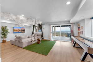 Spacious lower level featuring wood-finish flooring, recessed lighting, and a full-width sliding glass door leading to an outdoor deck