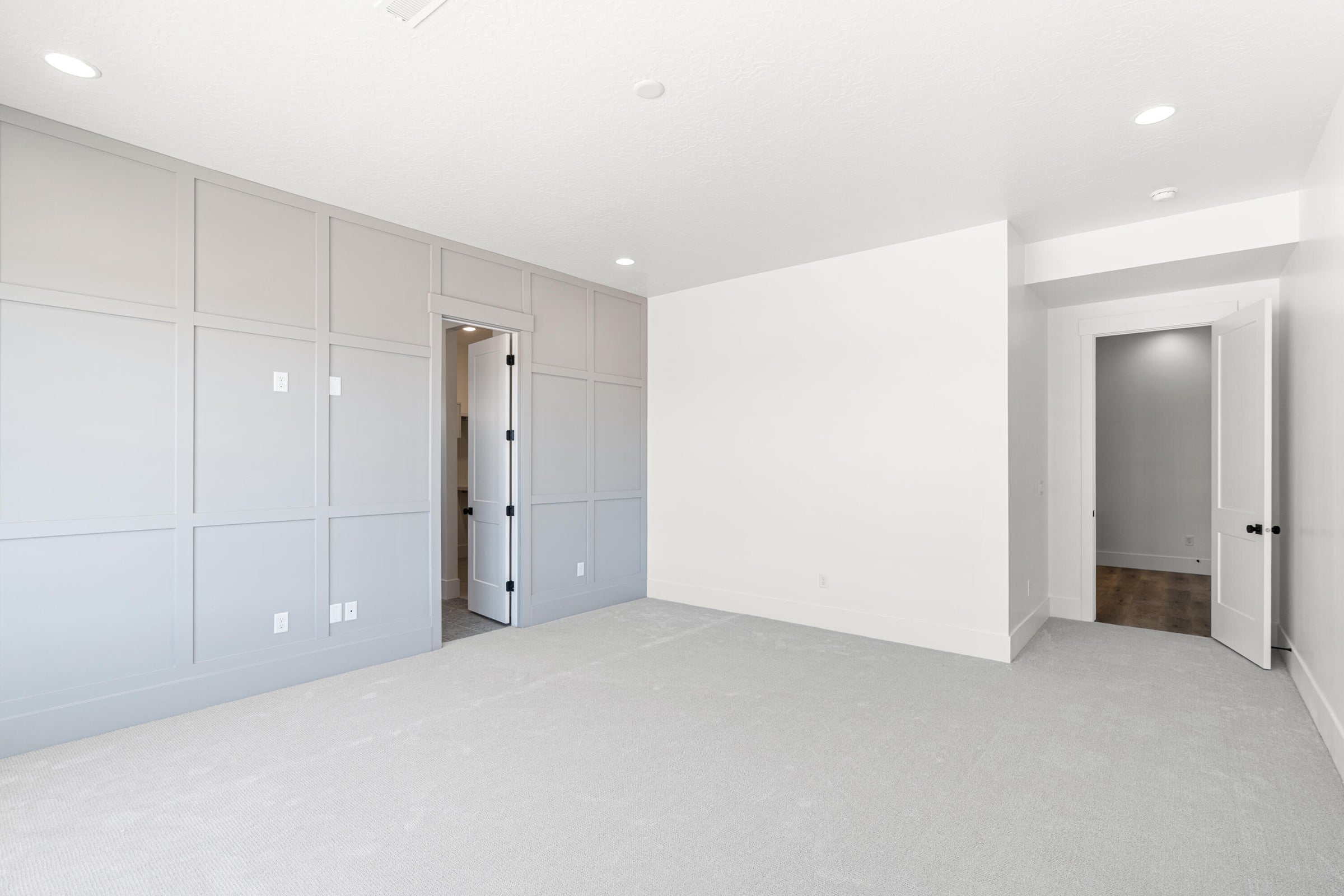 Spacious room featuring light gray carpeting and recessed lighting