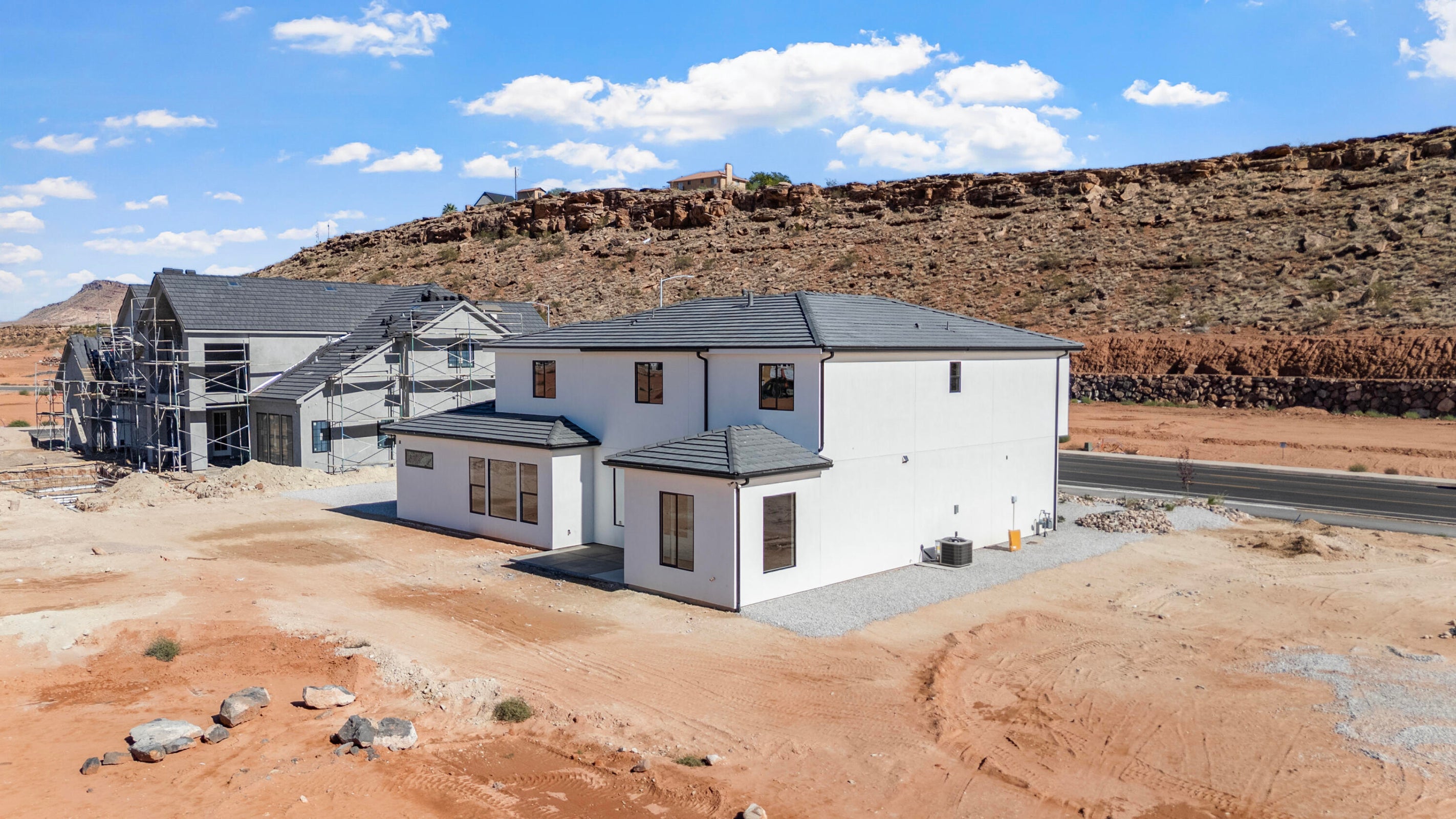 Newly constructed residence featuring white exterior siding and dark roof shingles
