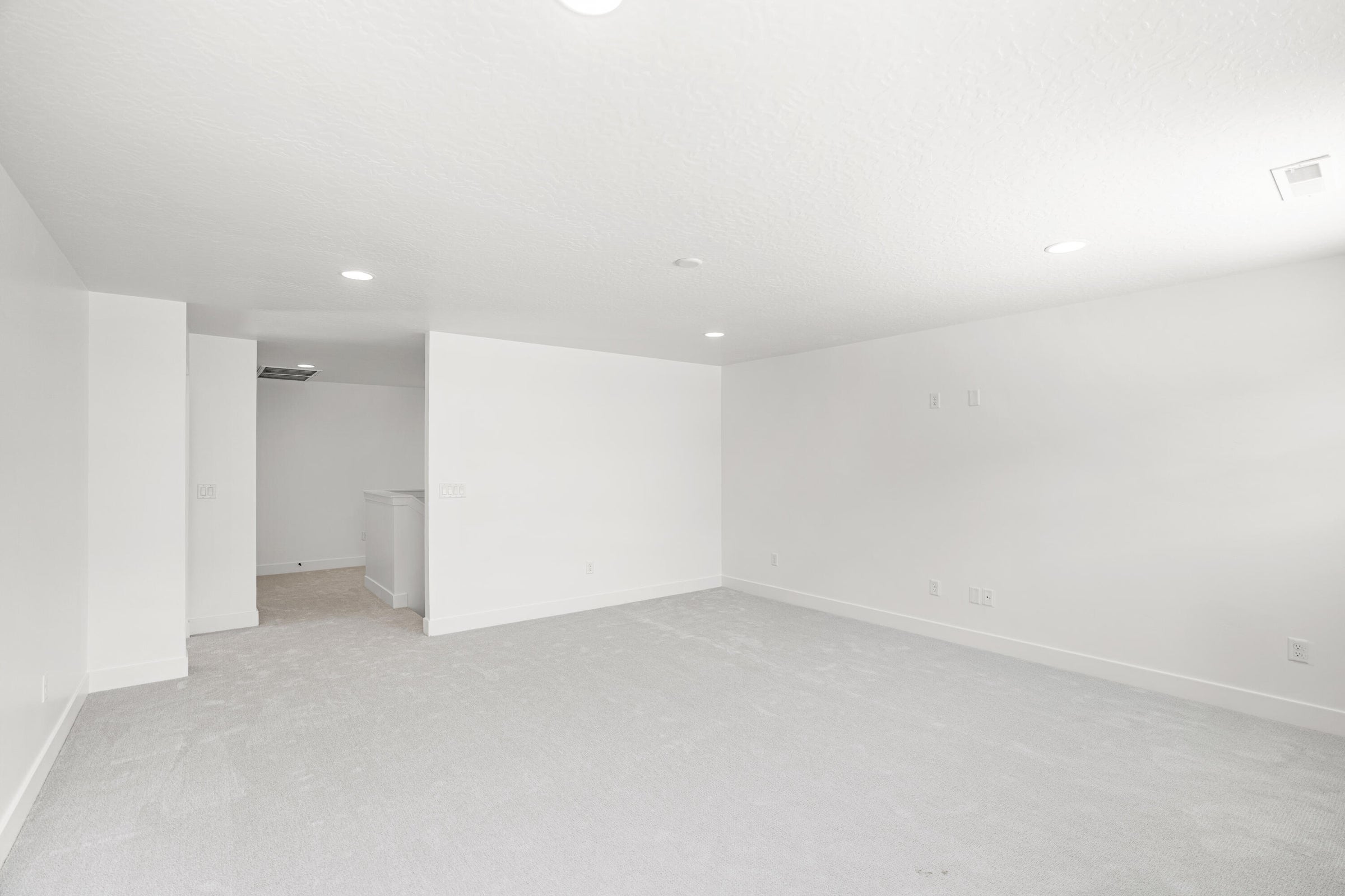 Spacious room featuring light-toned carpeting and recessed ceiling lighting