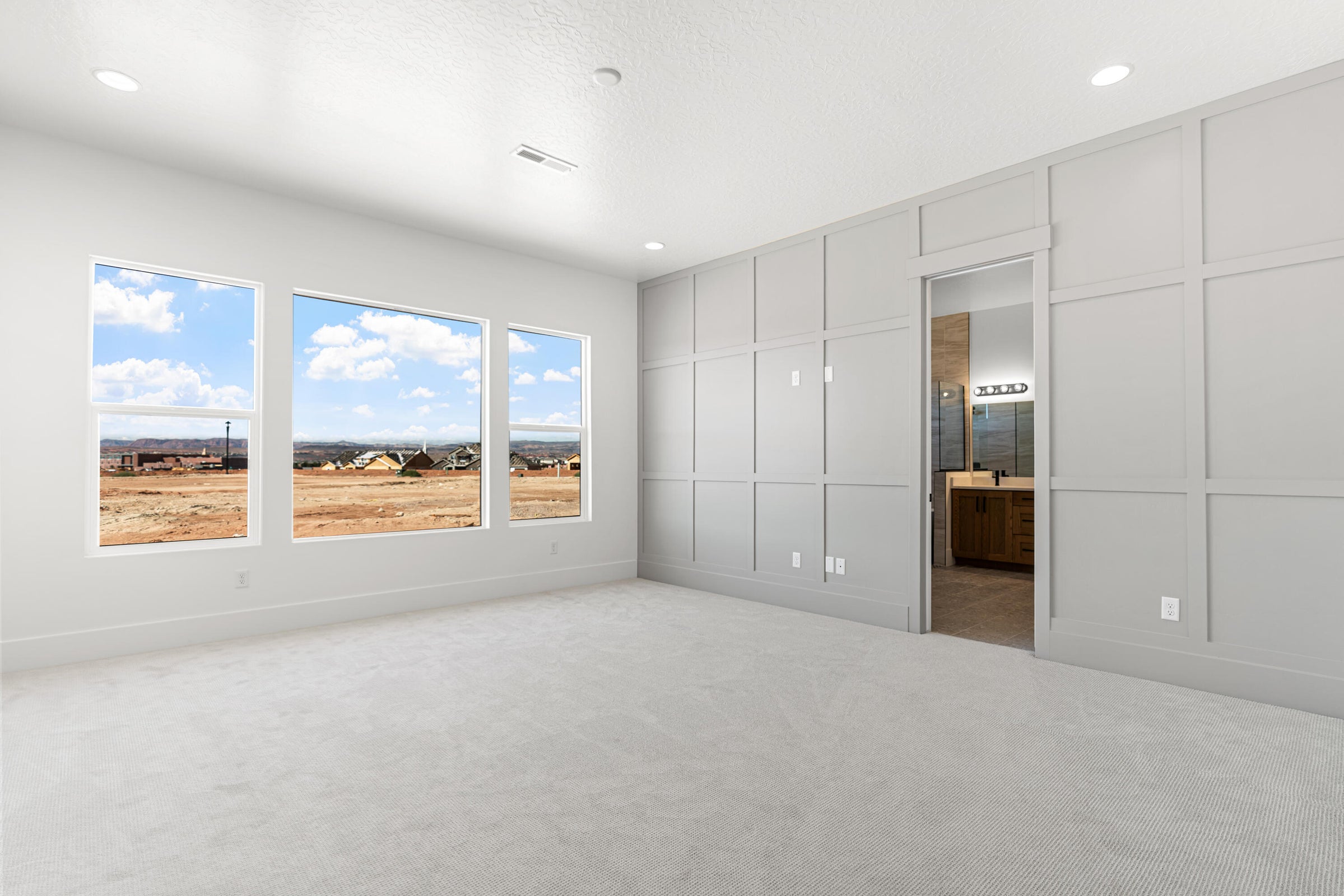 Spacious room with light gray carpeting and recessed lighting