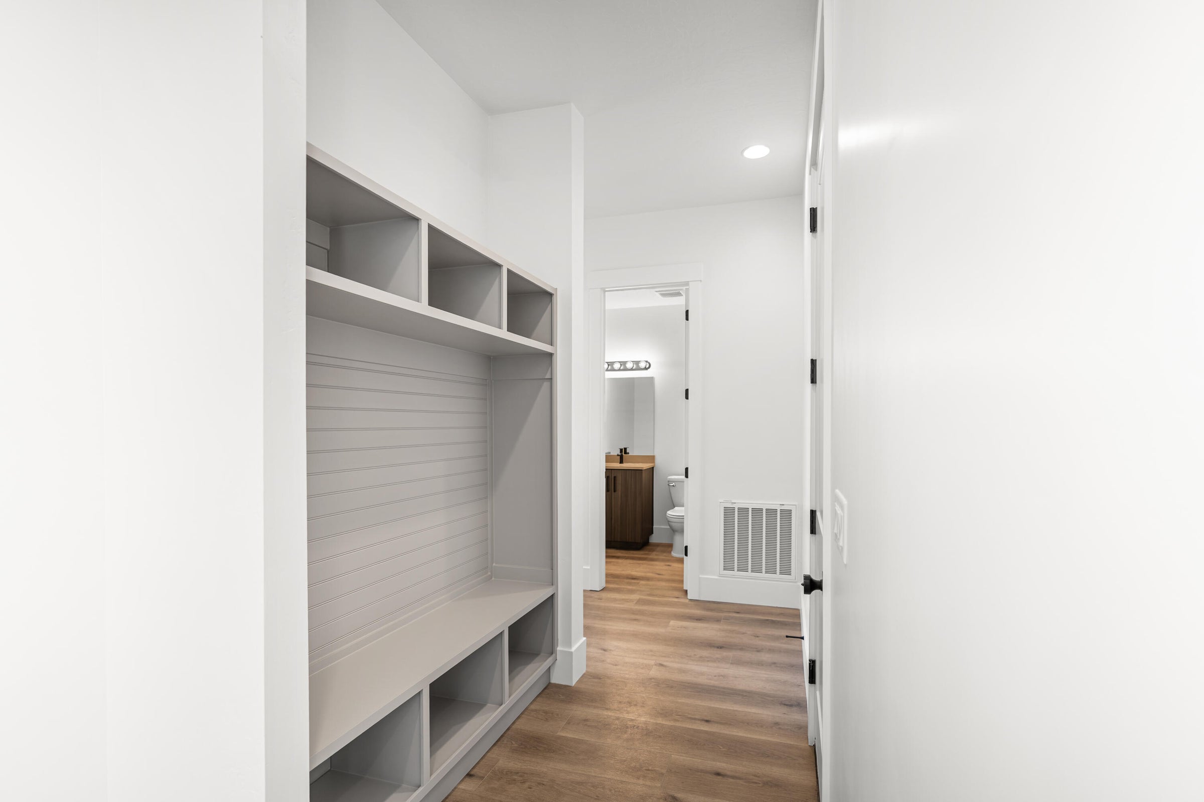 Built-in storage bench with multiple cubbies and upper shelving