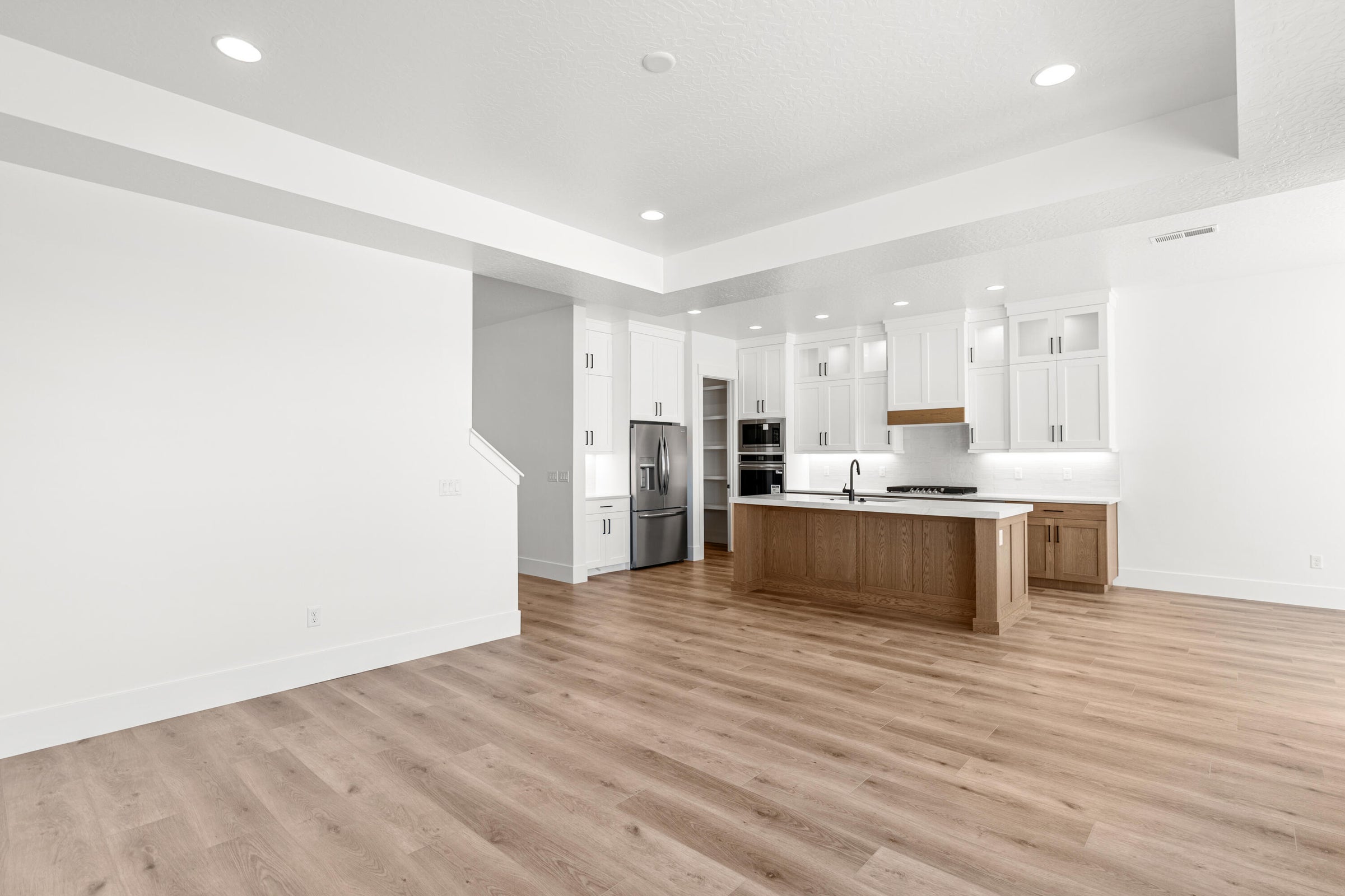 Open-concept living space featuring wood-finish flooring and recessed lighting