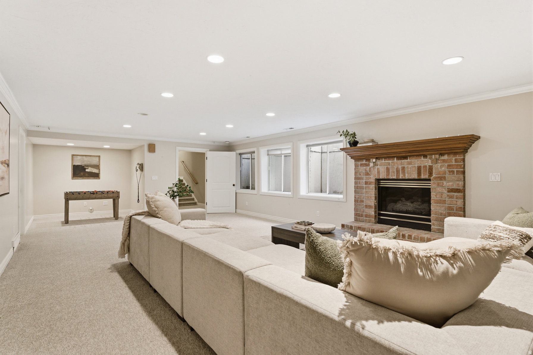 Spacious recreation room featuring light-colored carpeting and recessed lighting