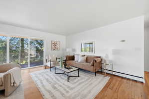 Spacious living area featuring wood-finish flooring and white walls