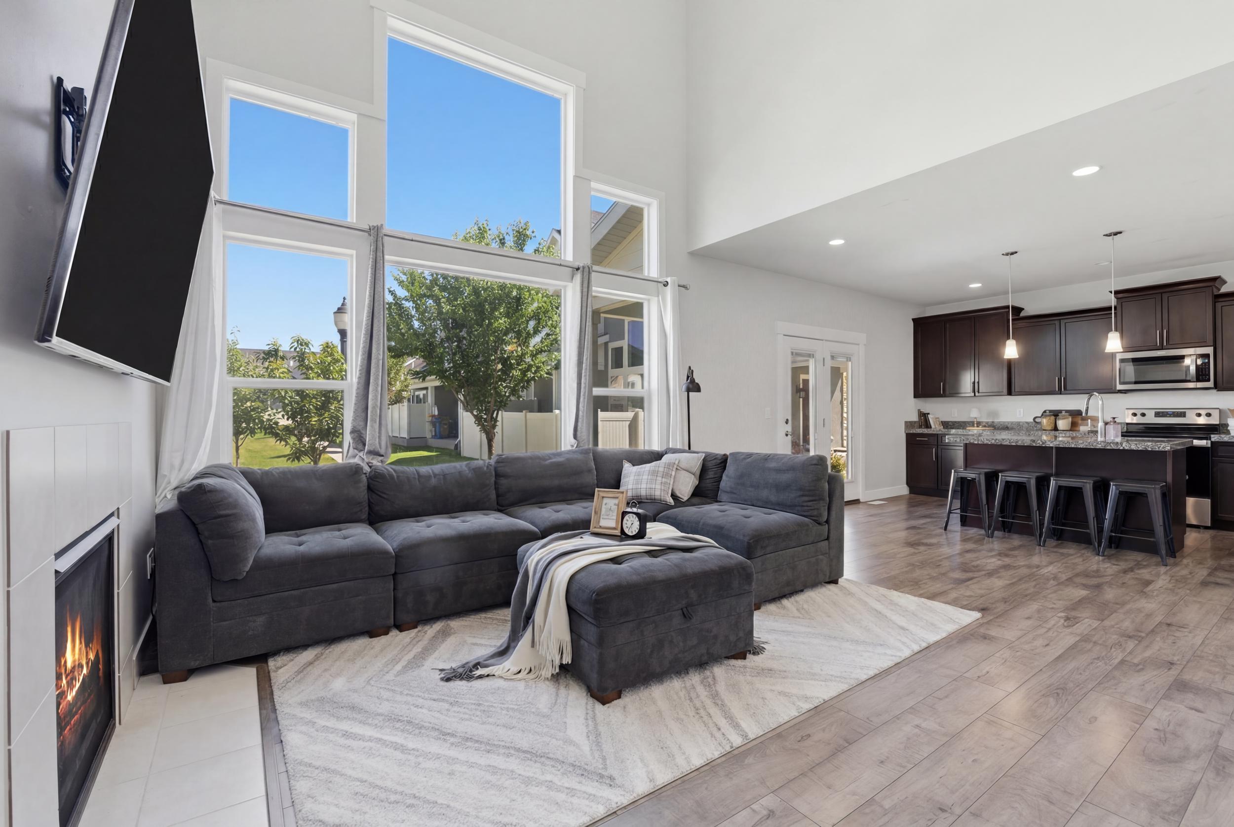Spacious living area featuring a vaulted ceiling and a fireplace with a white tile surround