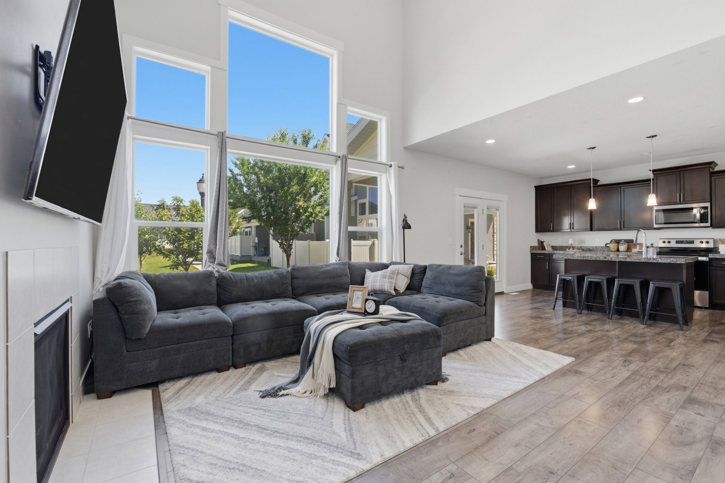 Two-story windows complement the vaulted ceilings in this open-concept living area
