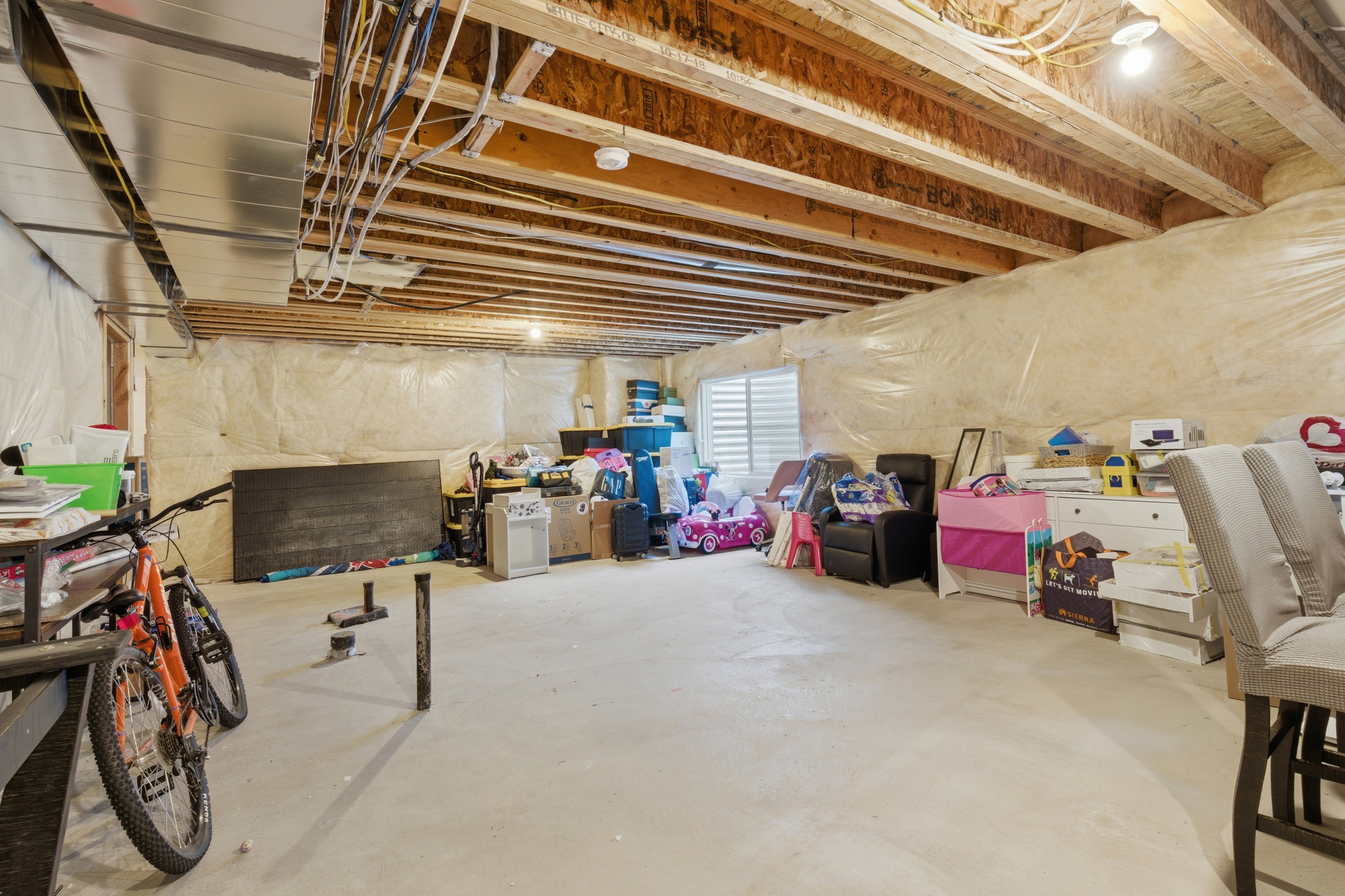 Unfinished basement featuring exposed wood joists and concrete flooring