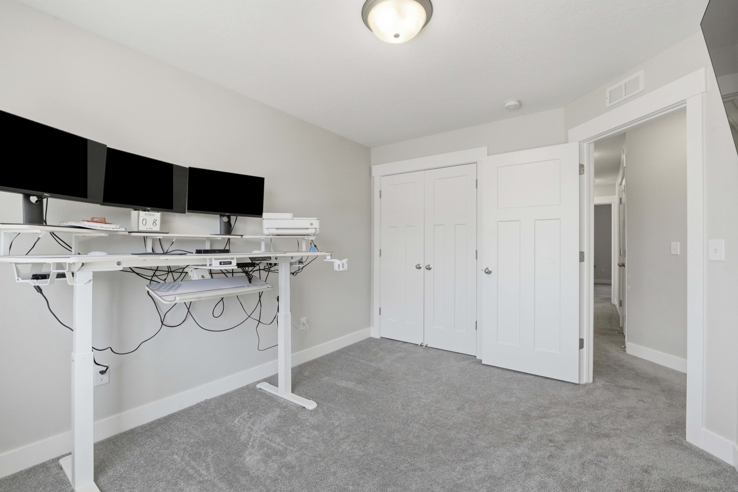 Carpeted room with light grey walls, white trim, and a semi-flush mount ceiling light