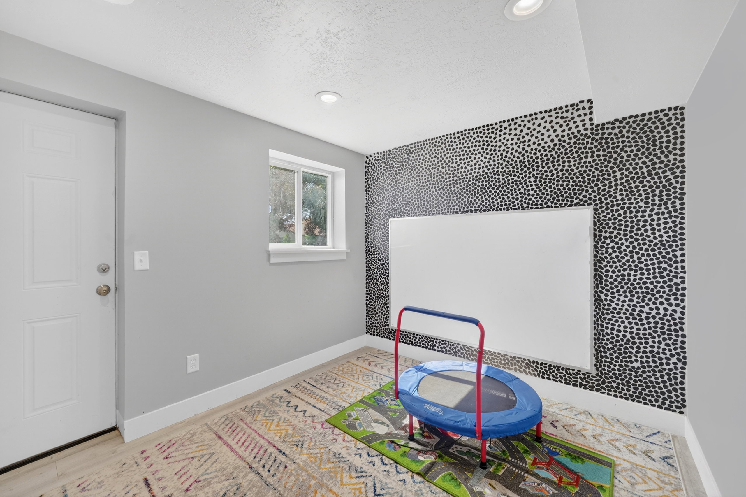 Recessed lighting illuminates this room featuring light-toned flooring and a window