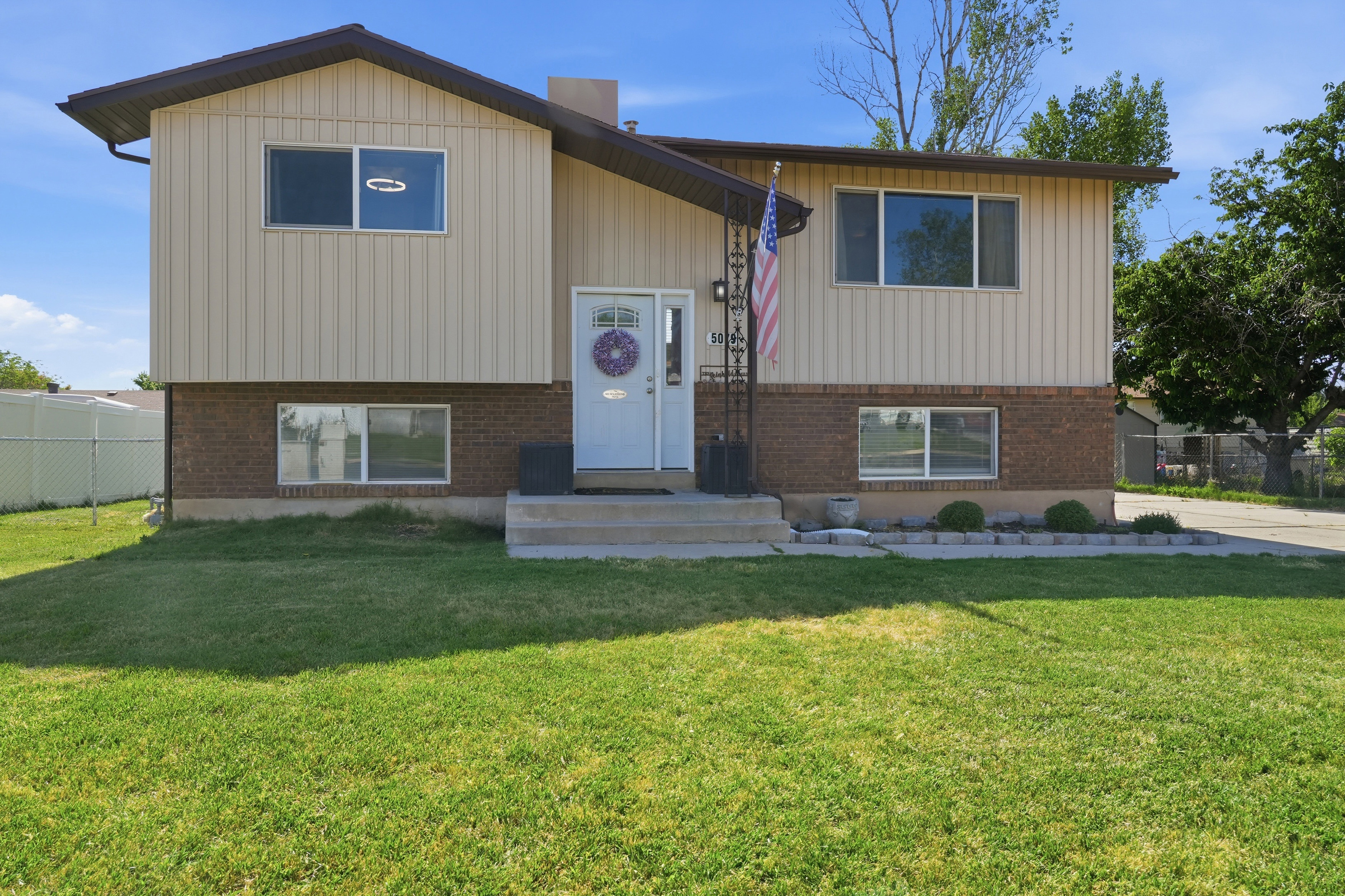 Split-level residence featuring brick and vertical siding