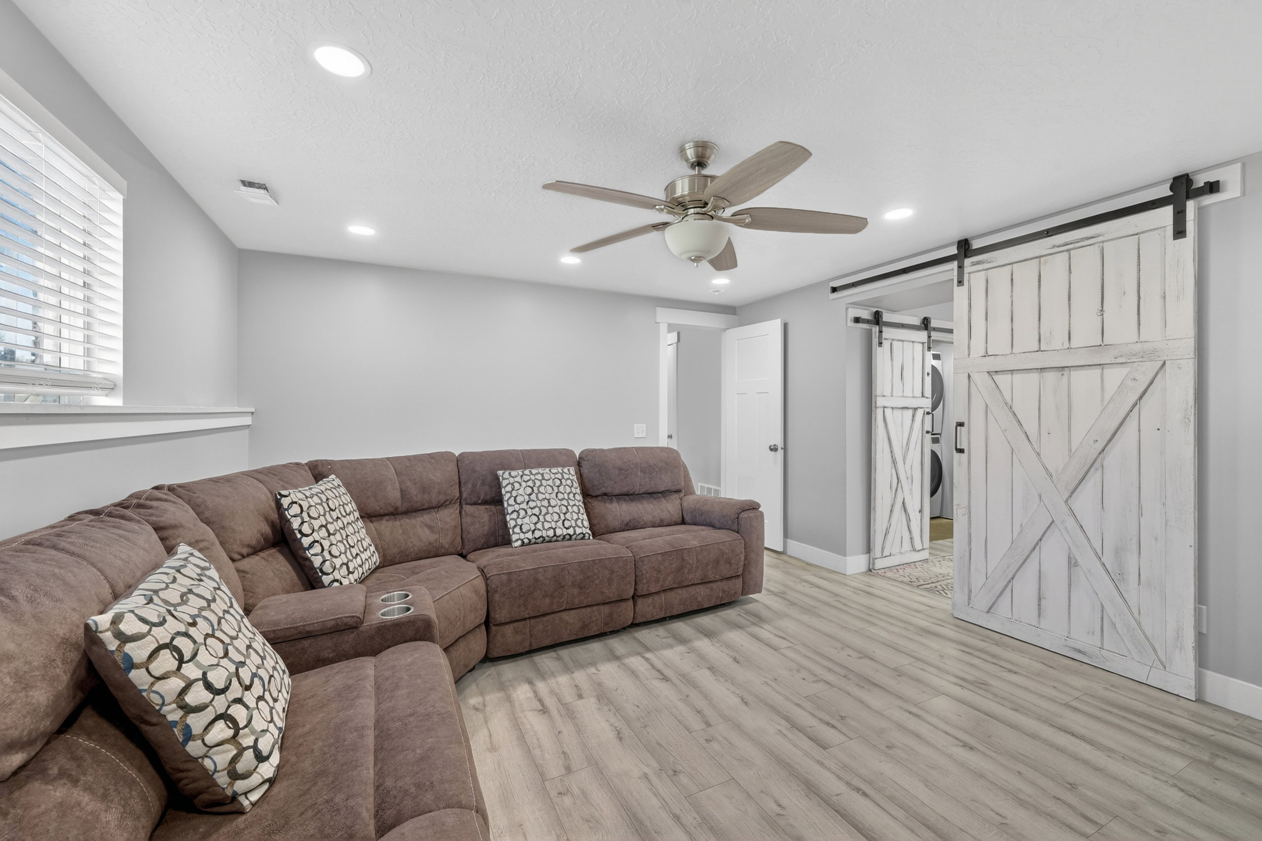 Spacious room featuring wood-finish flooring, recessed lighting, and a ceiling fan