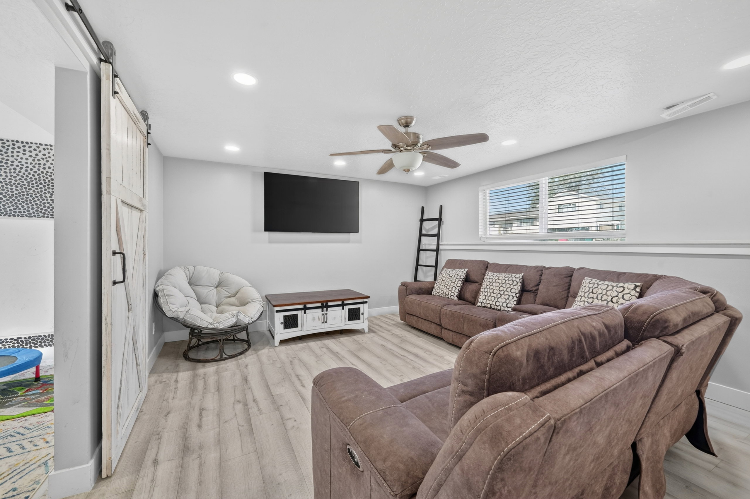 Bright entertainment space featuring recessed lighting and a ceiling fan