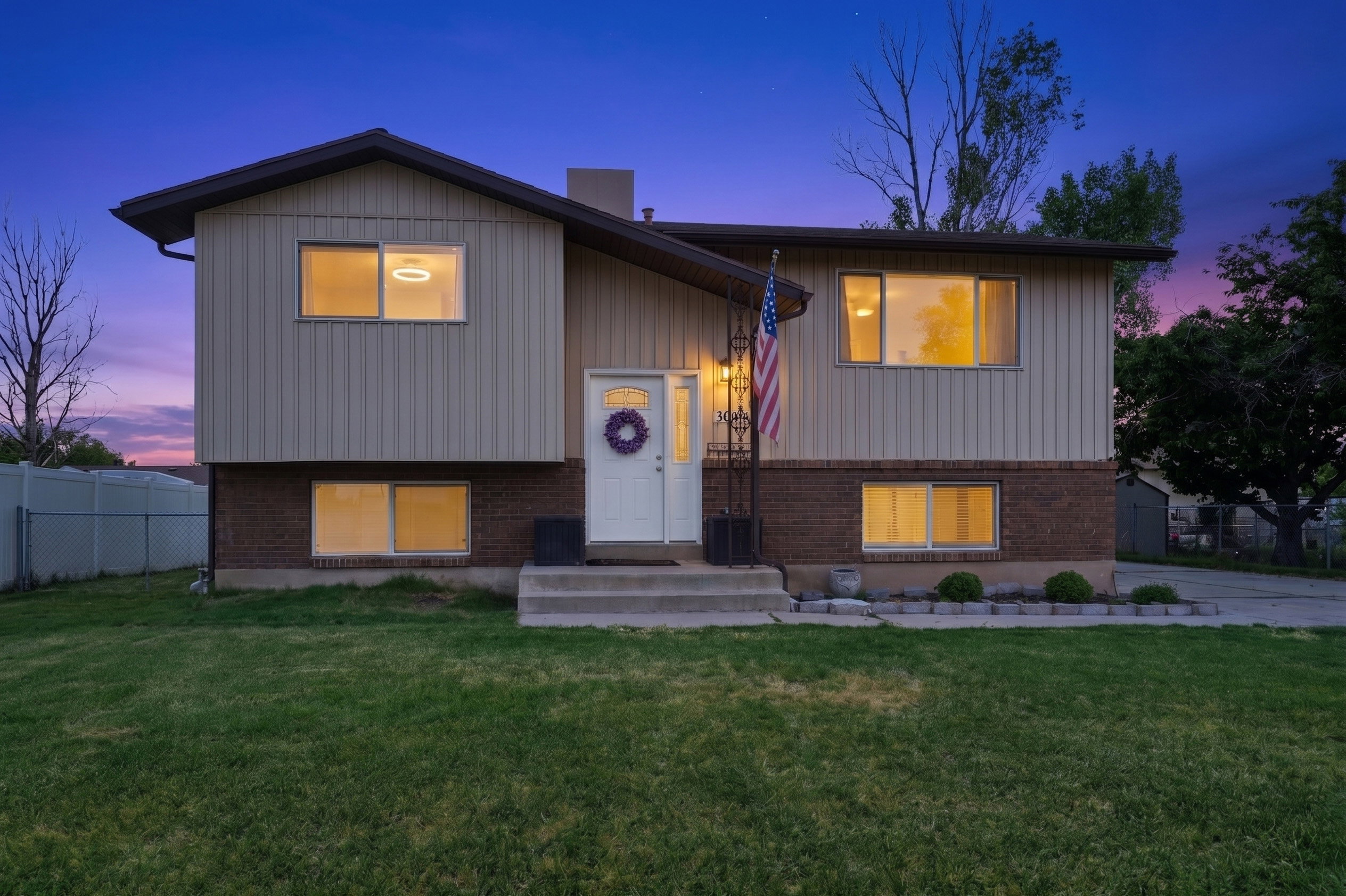 Split-level residence featuring a brick and vertical siding exterior
