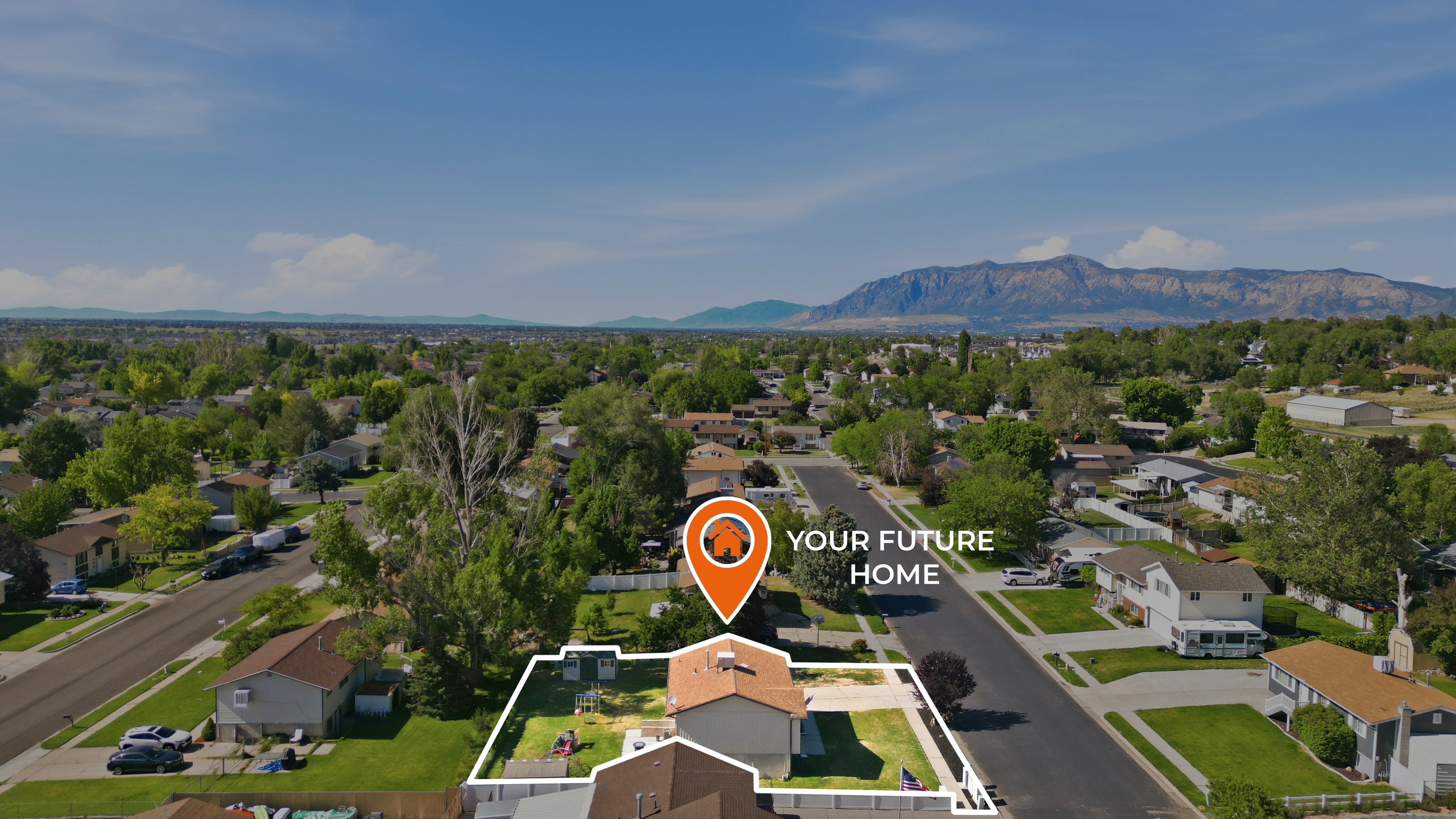 Aerial perspective showcasing a residential neighborhood with a prominent mountain range in the background