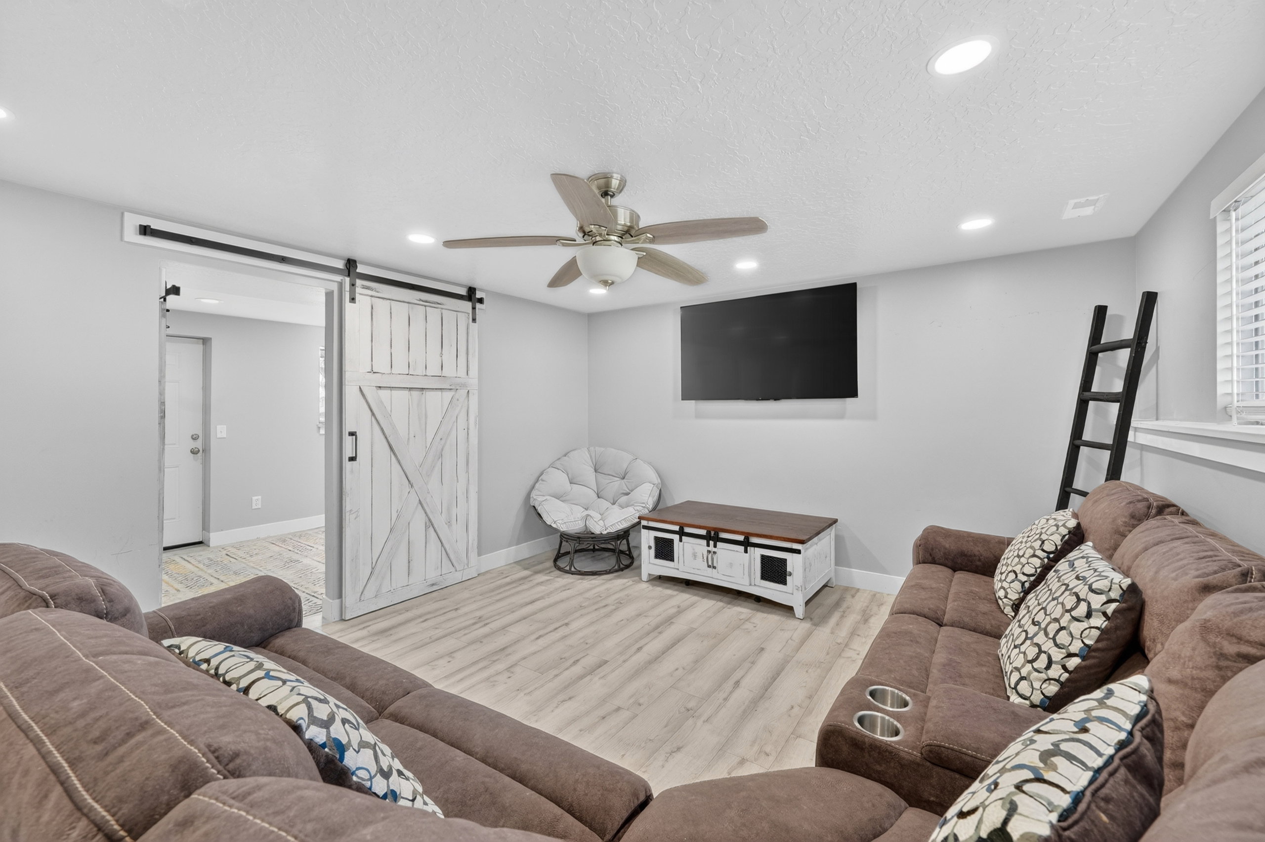 Spacious room featuring wood-finish flooring, recessed lighting, and a ceiling fan