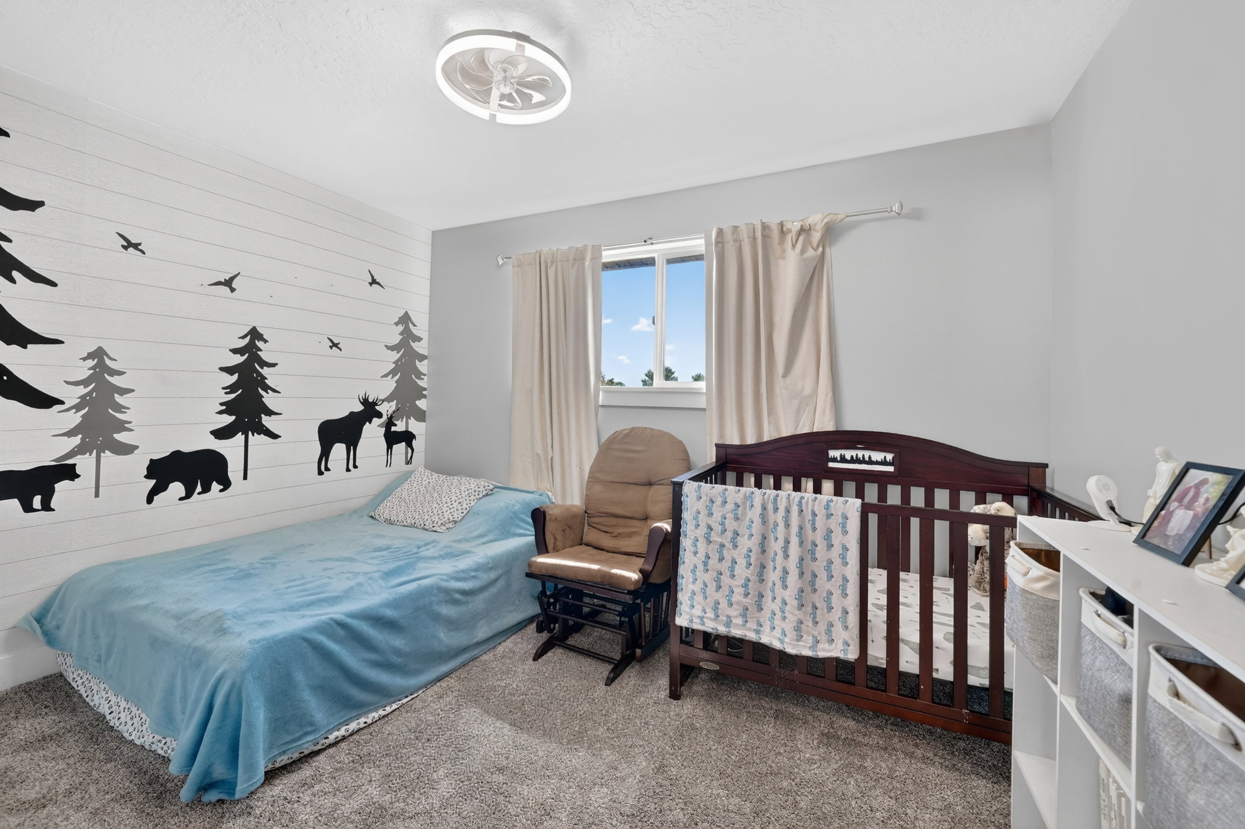 Bedroom featuring light gray wall paint and a shiplap accent wall