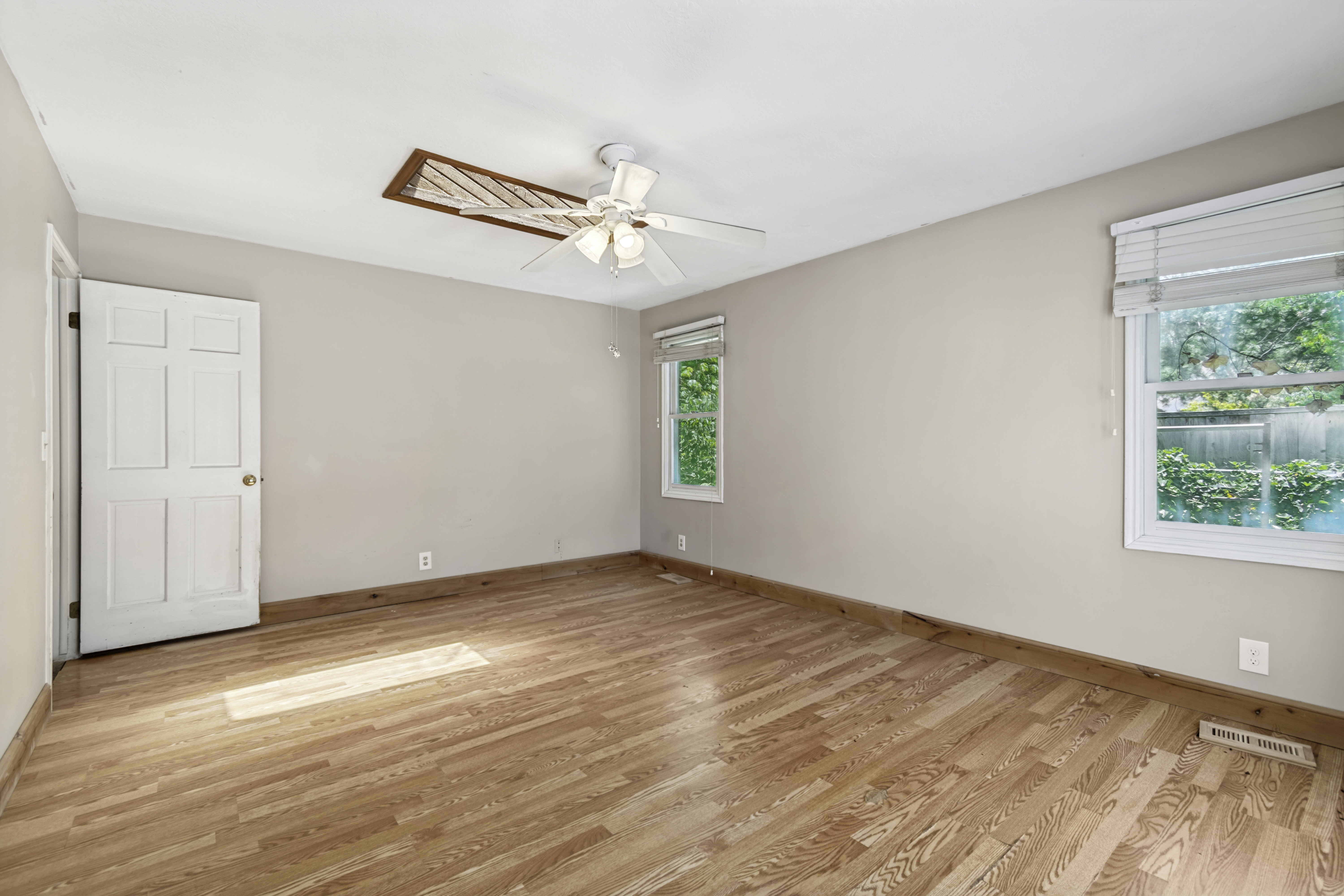 Wood-finish flooring throughout, complemented by light-toned walls and multiple windows