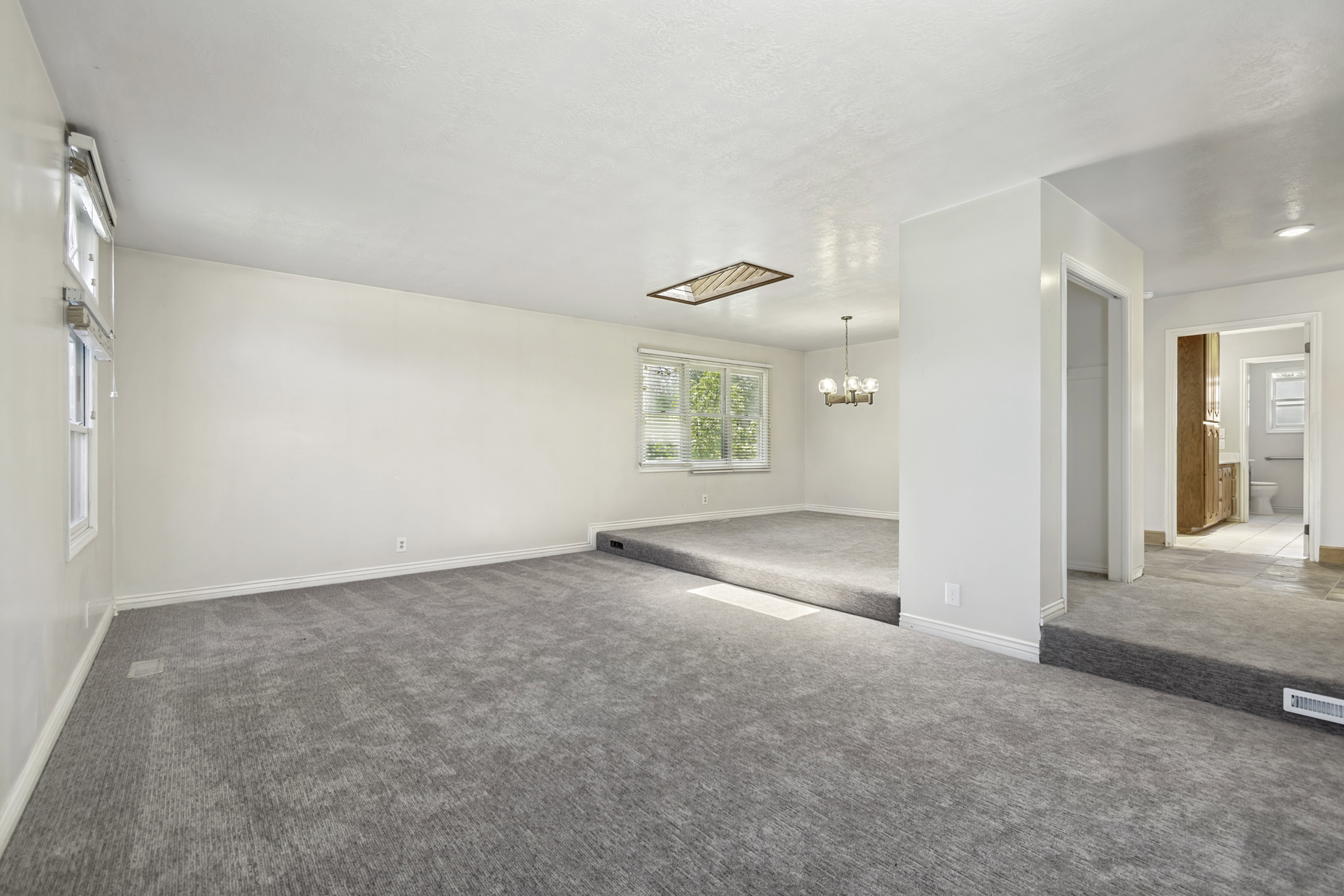 Spacious interior featuring light gray carpeting and white walls