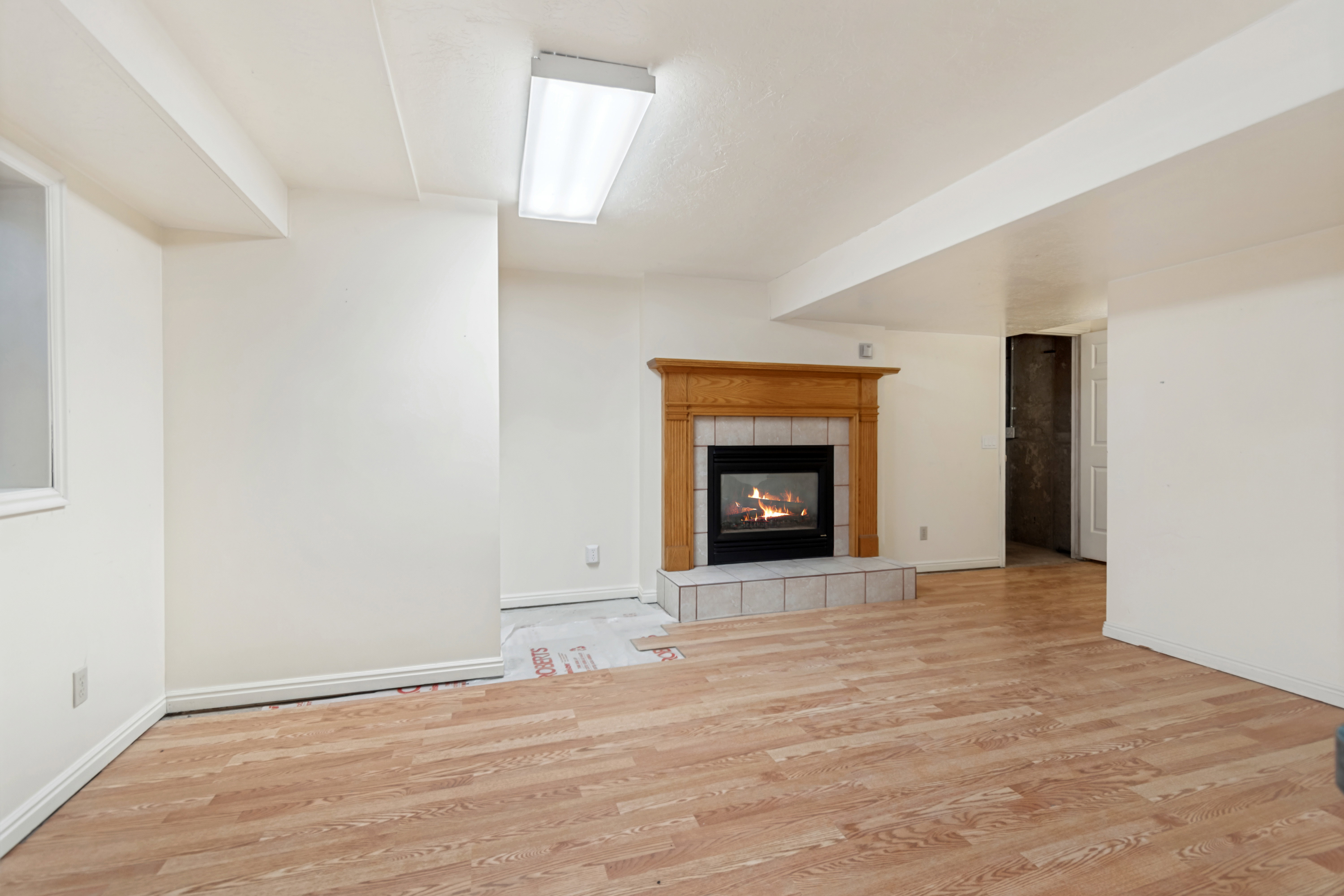 Fireplace with a wood mantle and tile surround, set against a light-colored wall