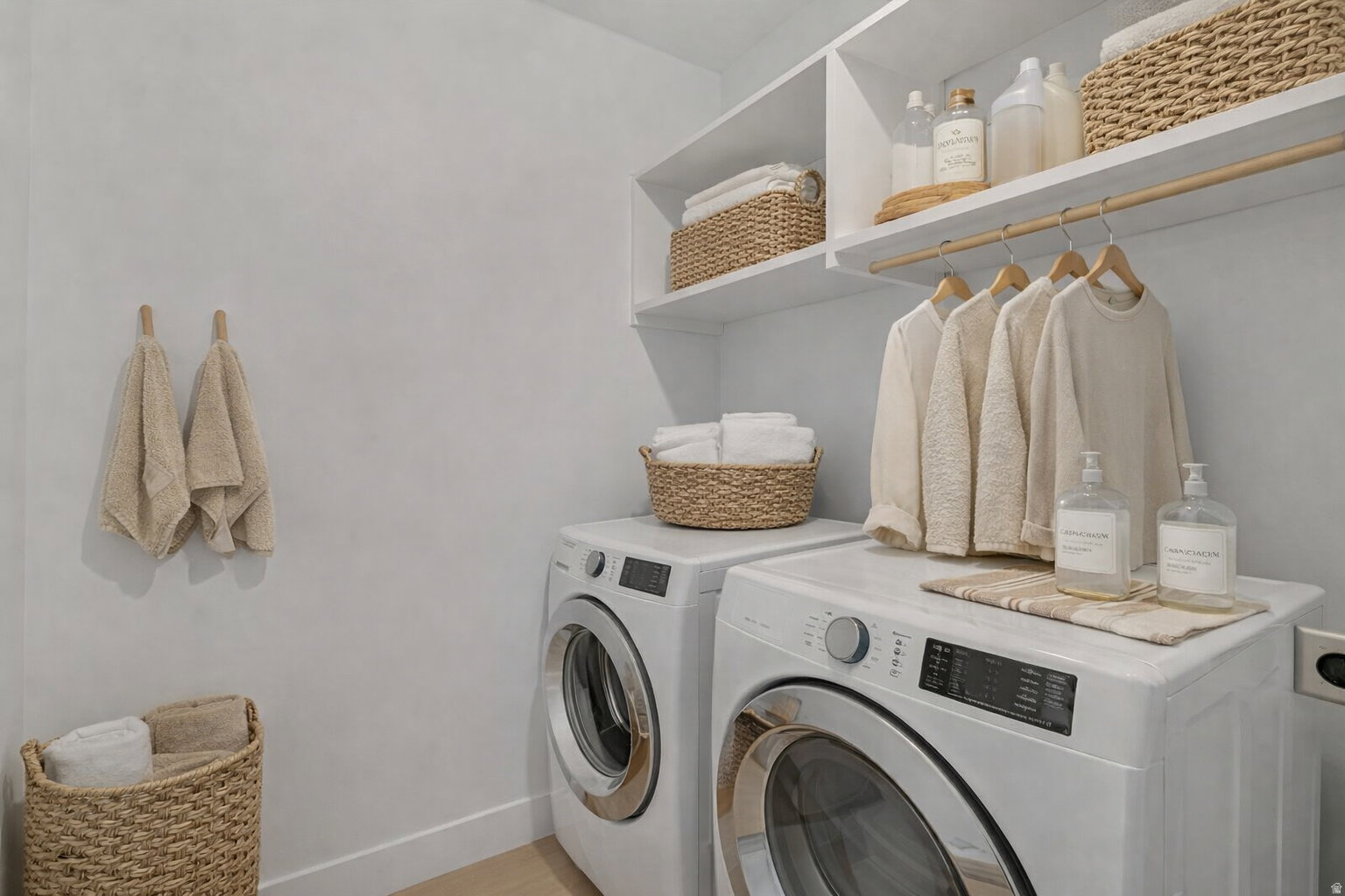 Dedicated laundry area featuring a front-loading washing machine, stacked dryer, built-in shelving, and a hanging rod for garments