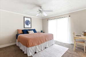 Neutral-toned bedroom featuring wall-to-wall carpeting, crown molding, and a ceiling fan