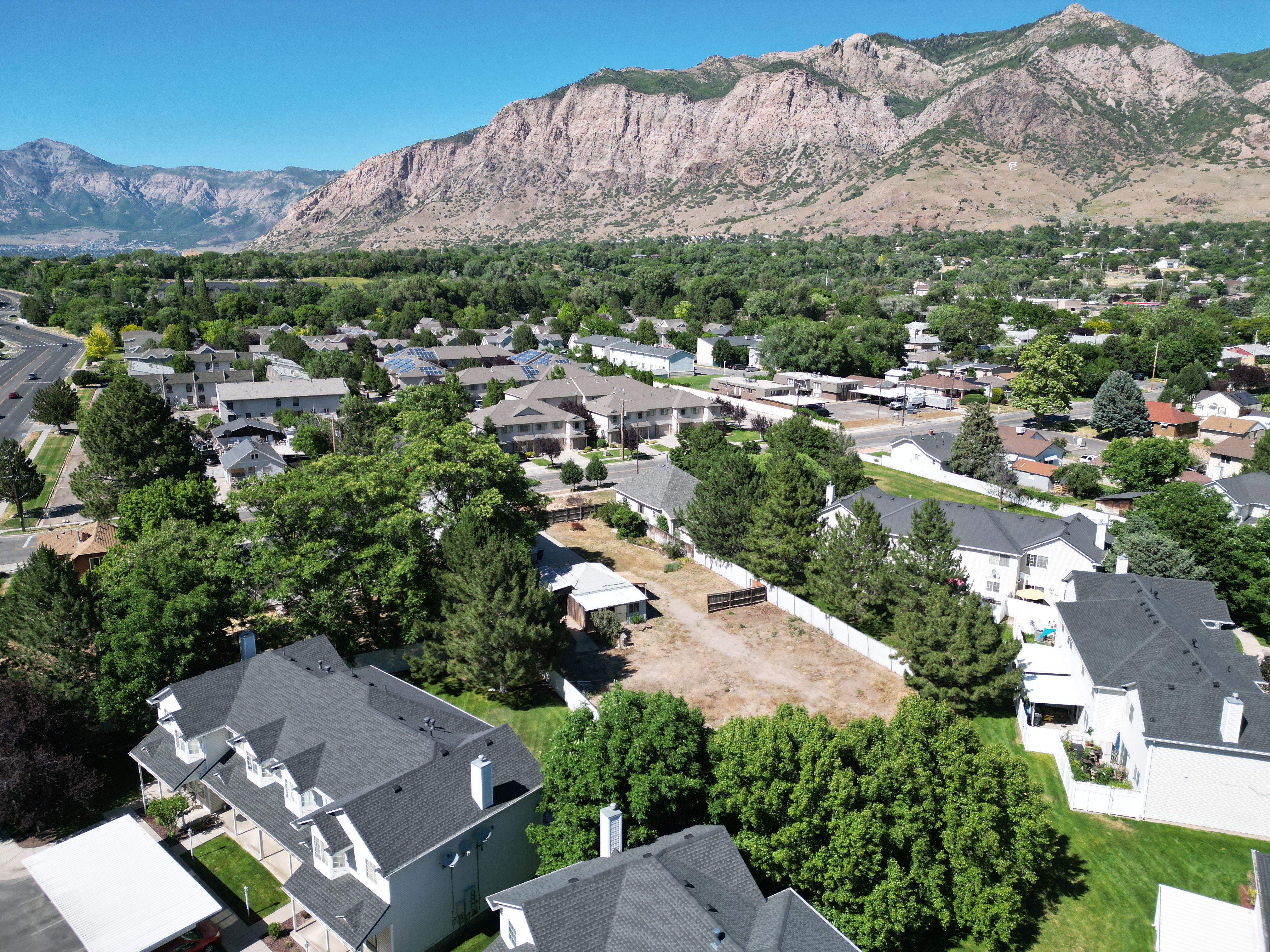 Expansive residential lot featuring a level grade and partial fencing, surrounded by mature trees and established properties