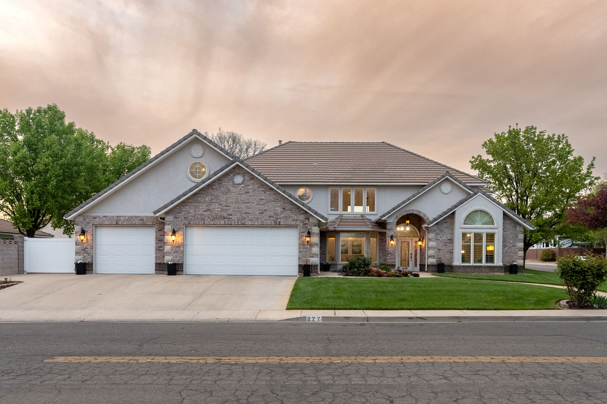 Stately residence featuring a stone and stucco exterior, tile roof, and a three-car garage