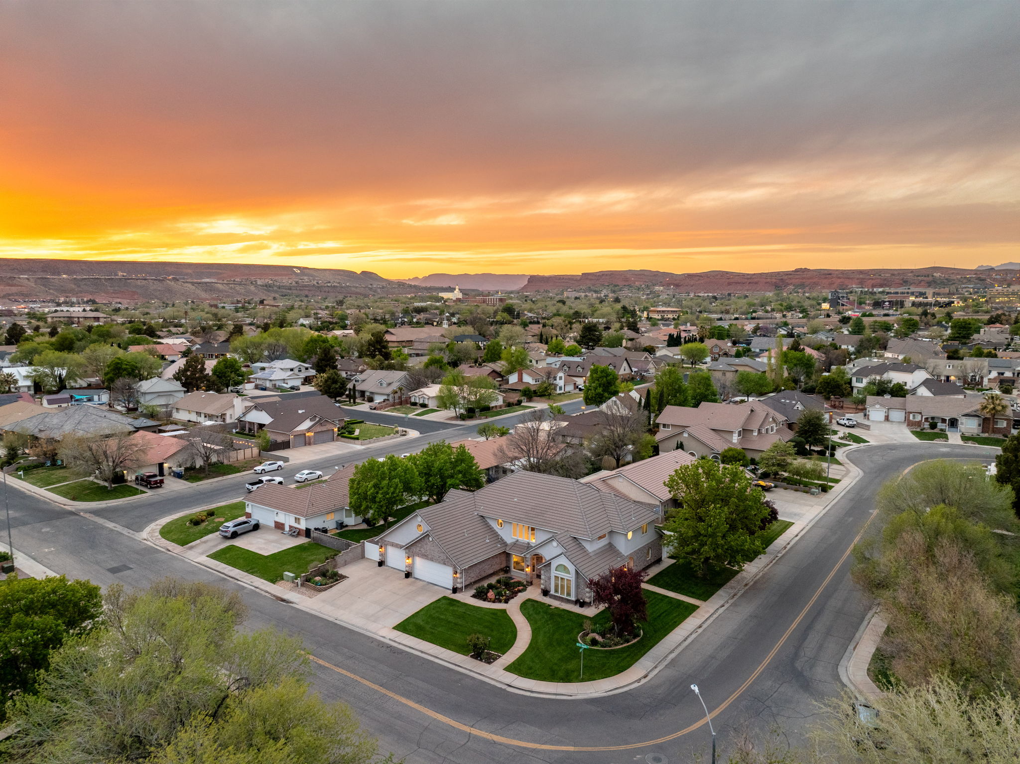 Residential neighborhood with mature trees and a distant mountainous backdrop