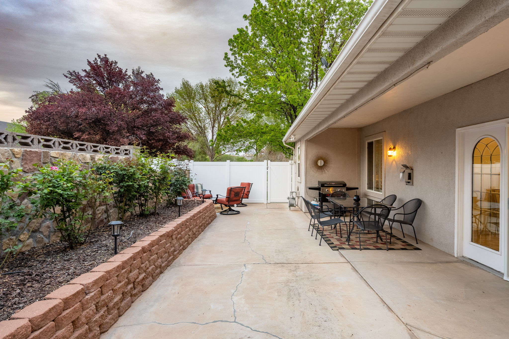 Concrete patio with an adjacent stone retaining wall and a separate brick retaining wall