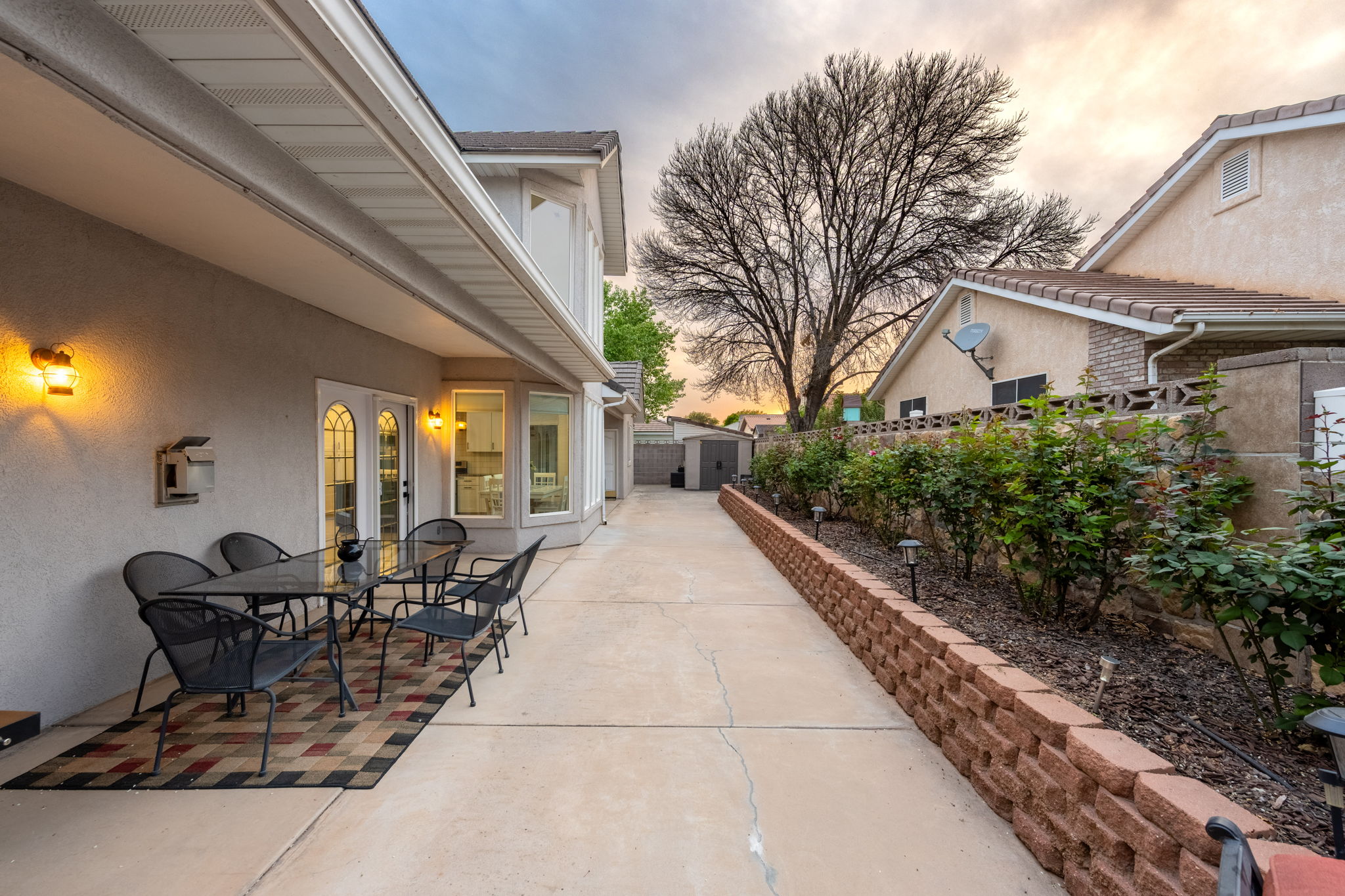Covered patio with exterior wall sconces, French doors, and a bay window