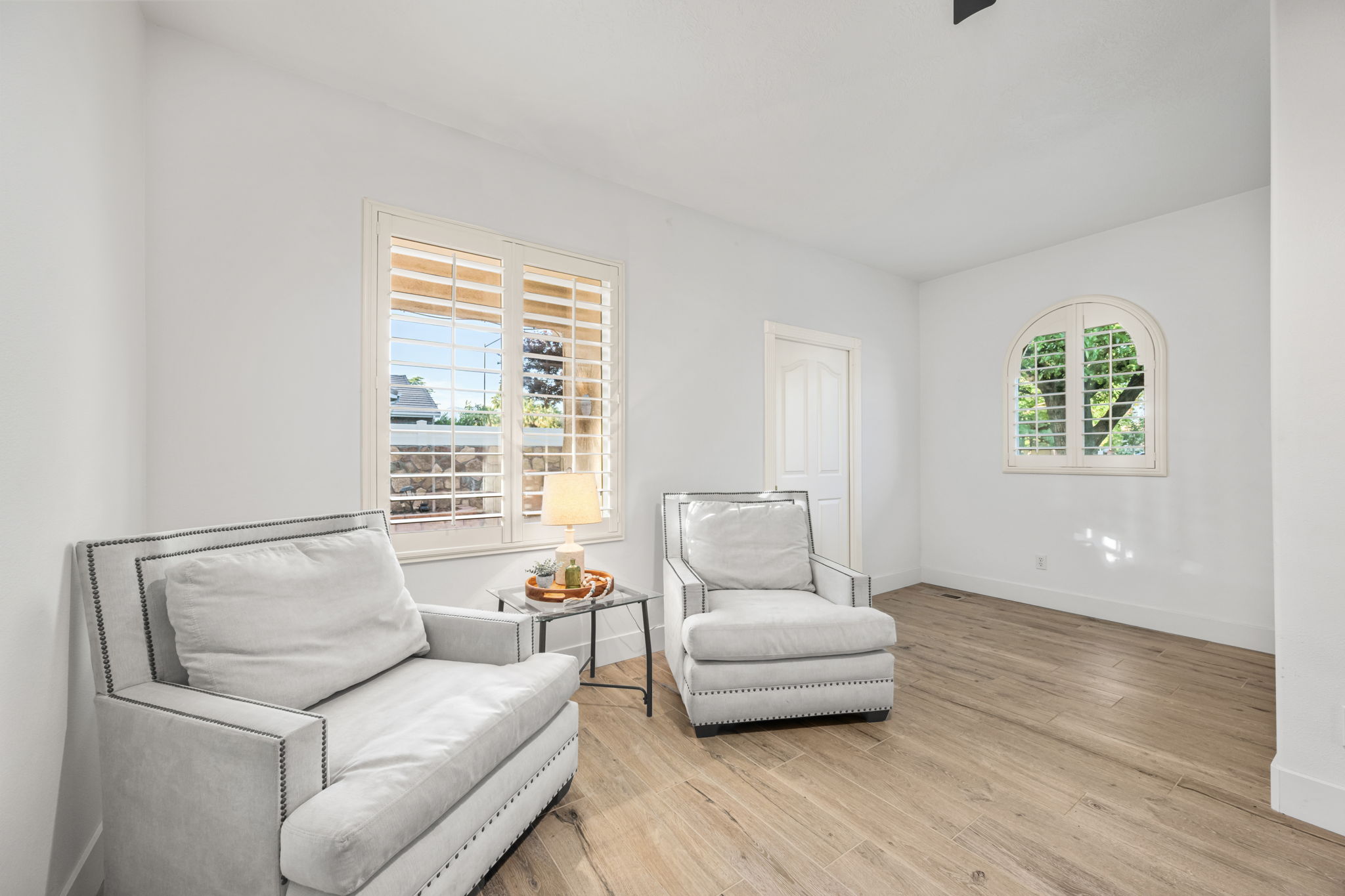 Room featuring light wood-finish flooring, white walls, and a white interior door