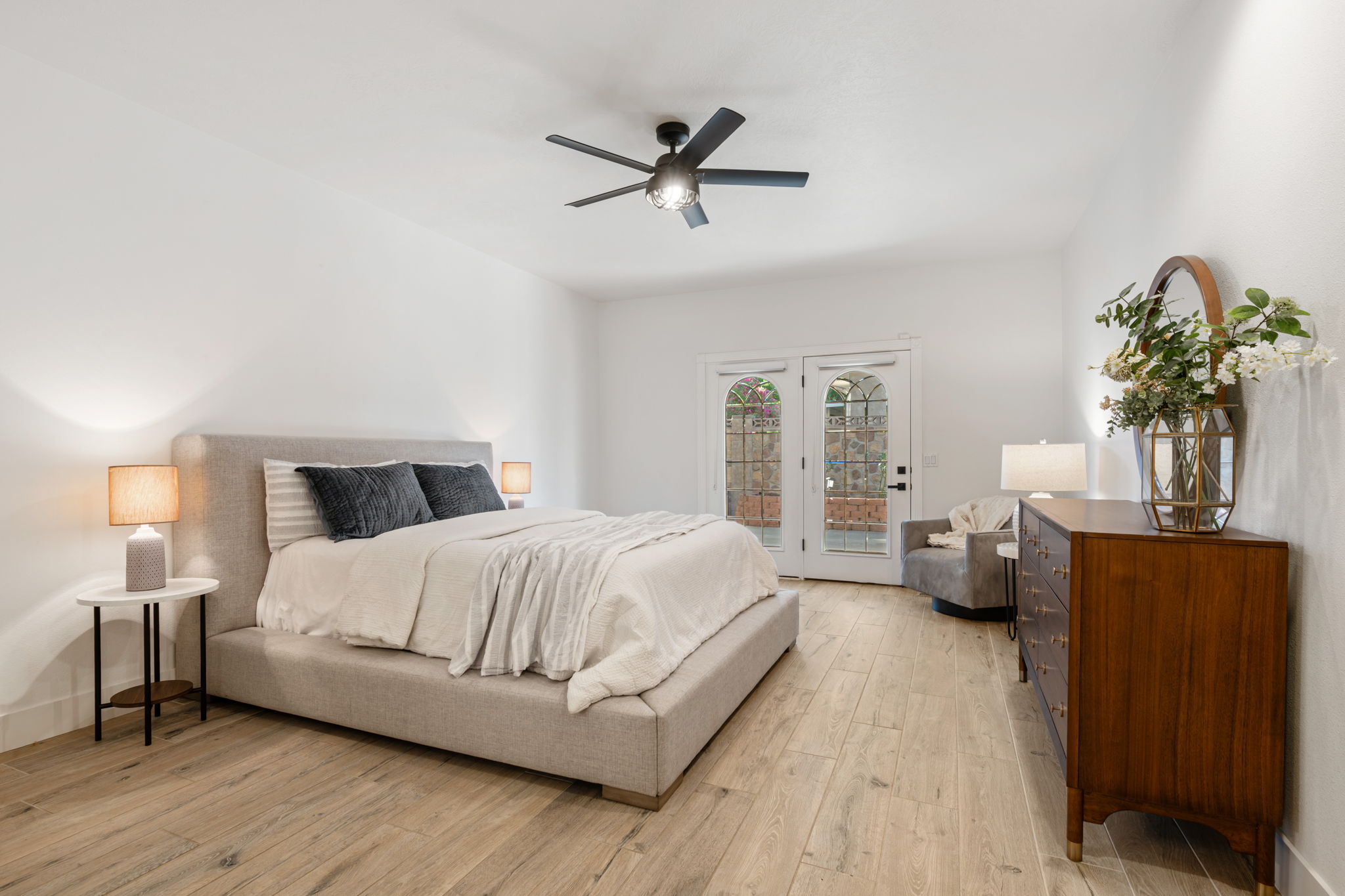 Spacious room featuring wood-finish flooring and a ceiling fan with integrated lighting