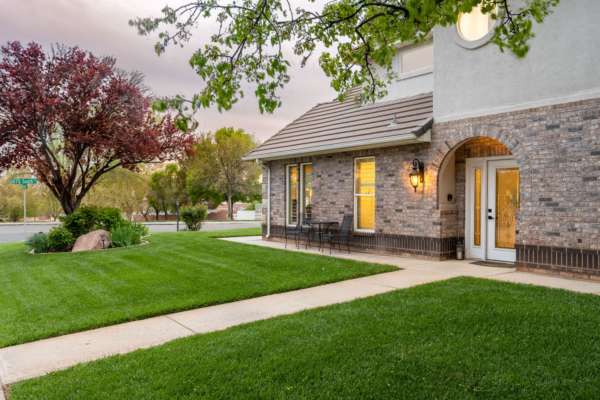 Brick and stucco exterior with an arched entryway and double glass panel doors