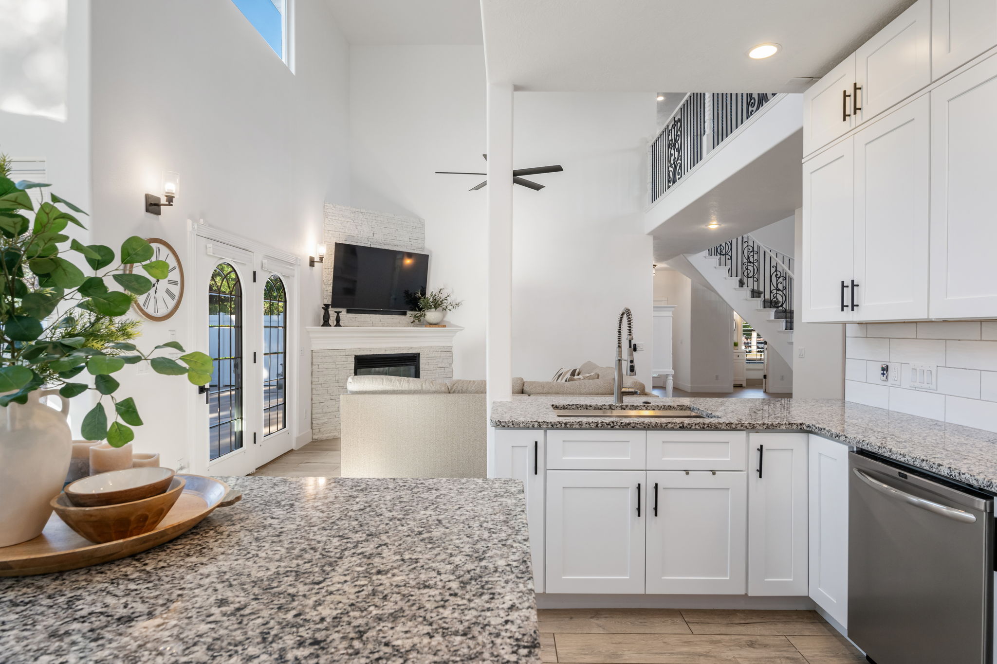Kitchen featuring granite countertops, white cabinetry with black hardware, and a stainless steel dishwasher