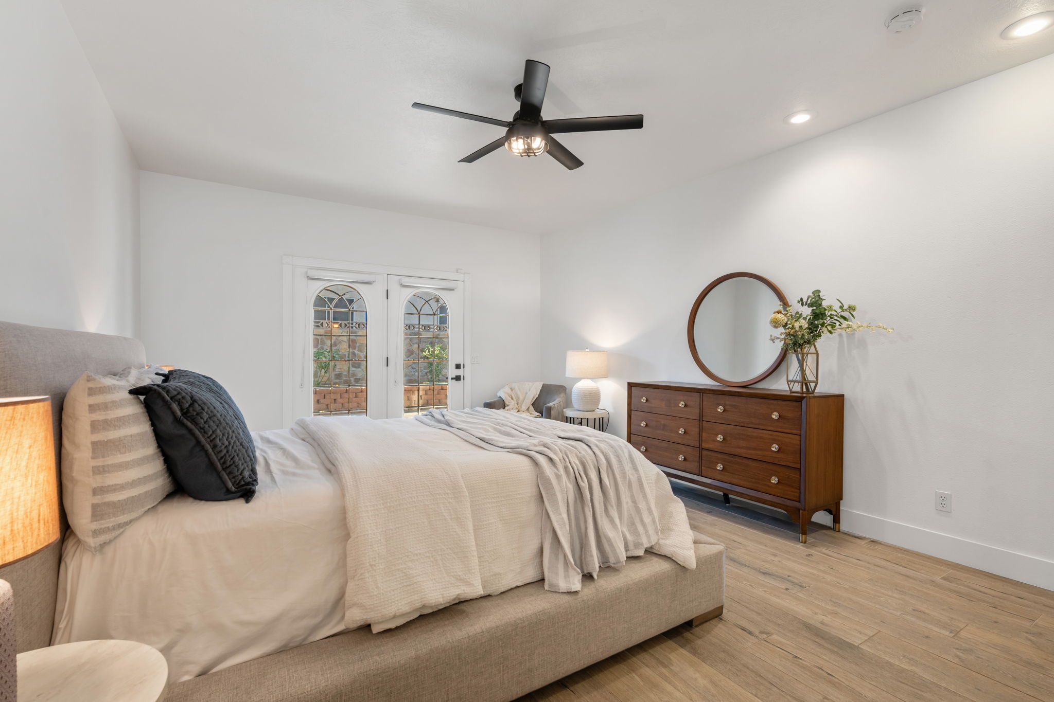 Bedroom featuring arched double doors, wood-finish flooring, a contemporary ceiling fan, and recessed lighting