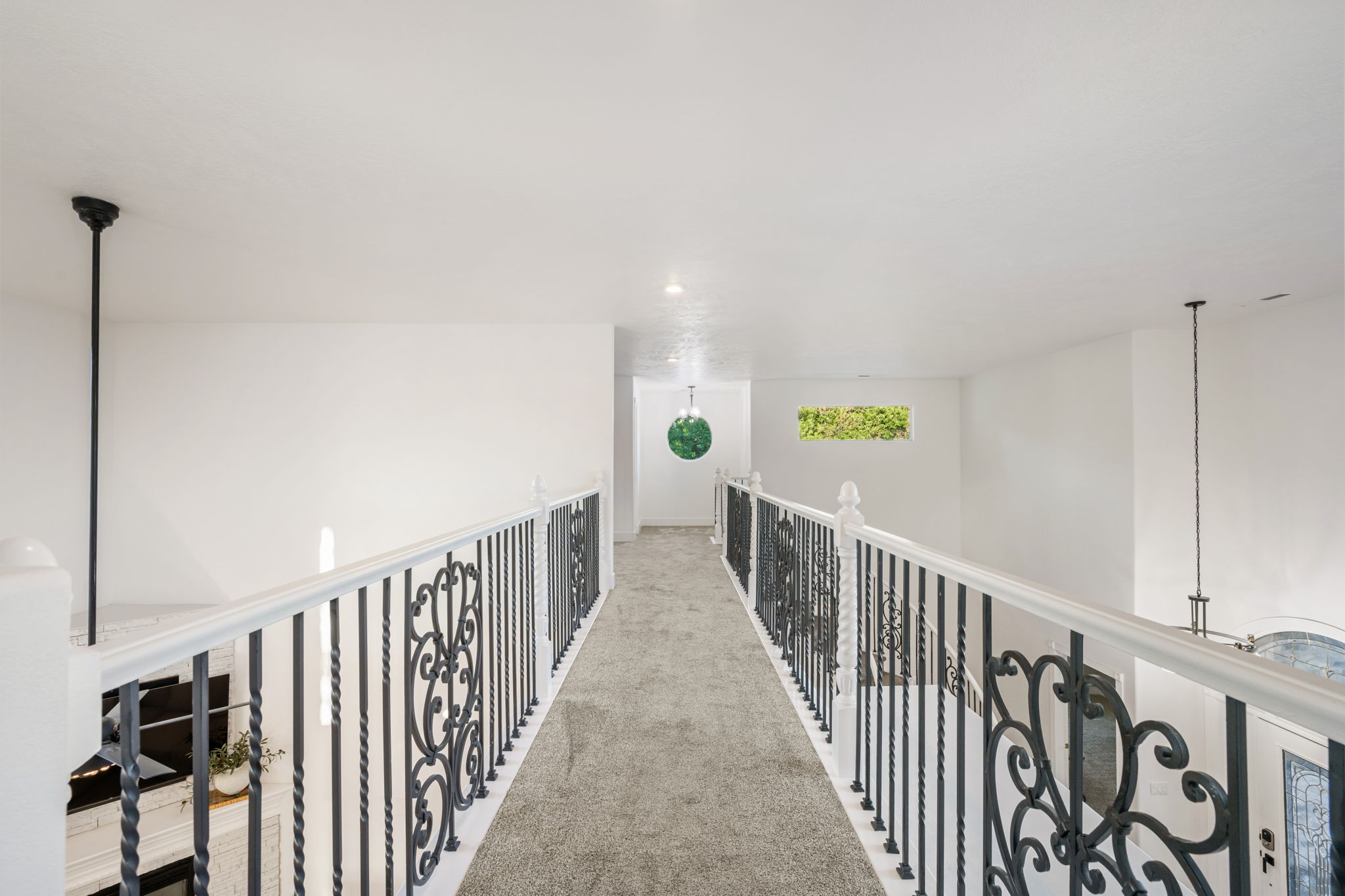 Upper-level walkway featuring elegant wrought iron railings with decorative scrollwork and a white handrail