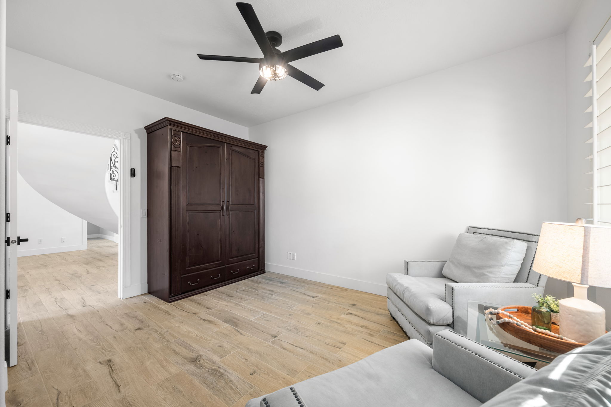 Light wood-finish flooring complements the bright white walls of this interior space