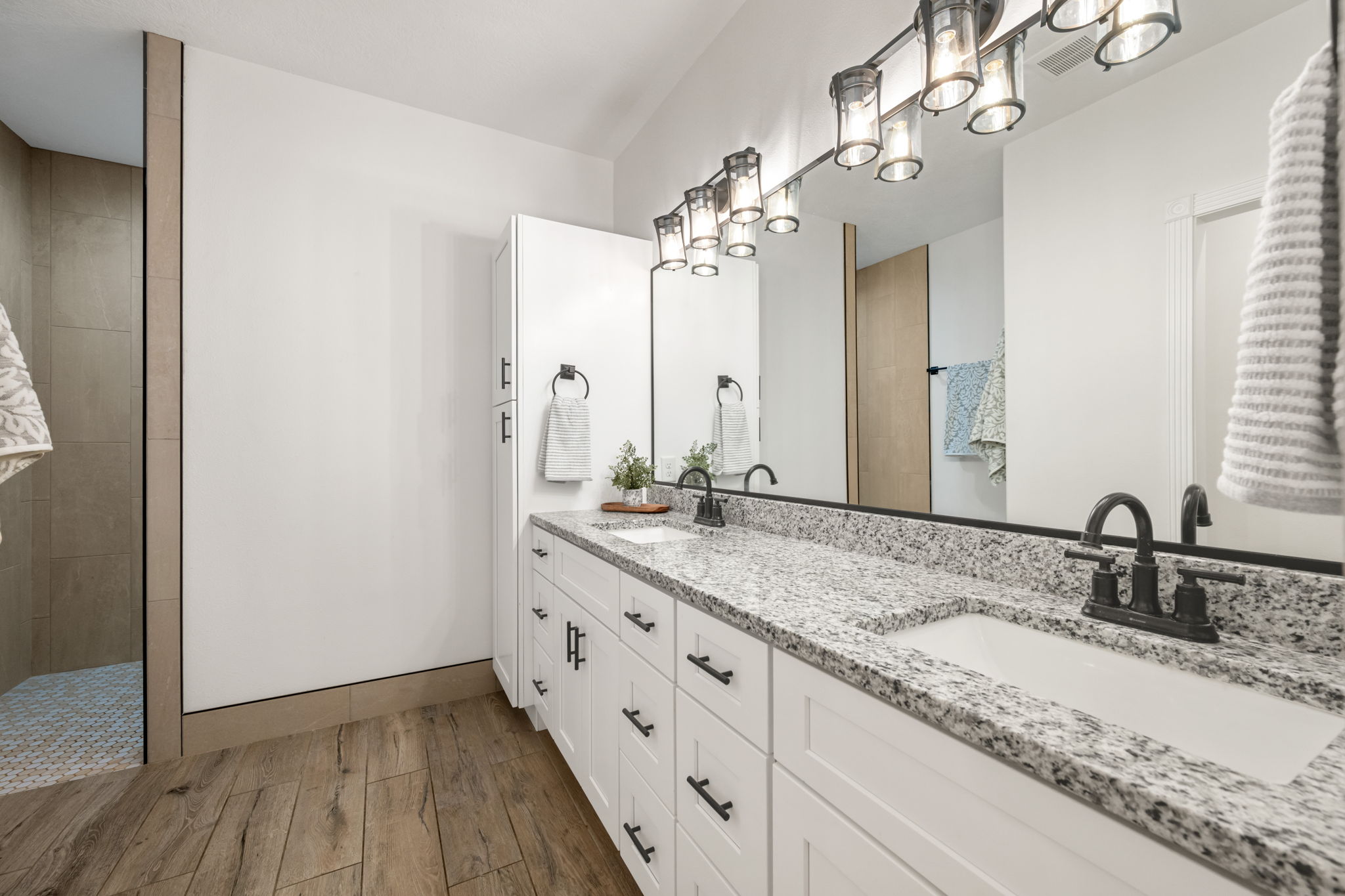 Dual vanity with granite countertop, integrated sinks, and matte black hardware