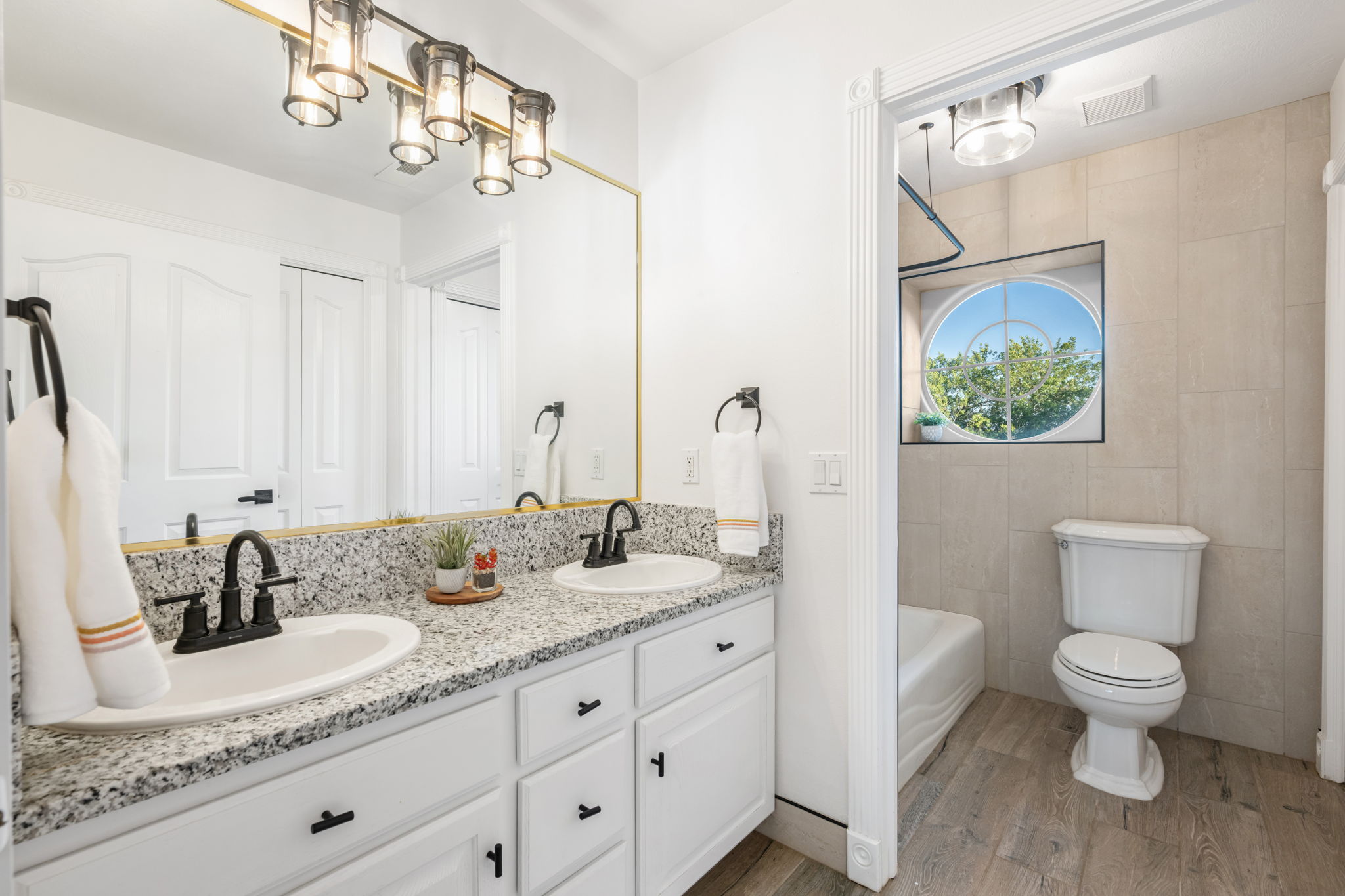 Bathroom featuring a double vanity with granite countertops, undermount sinks, and matte black fixtures