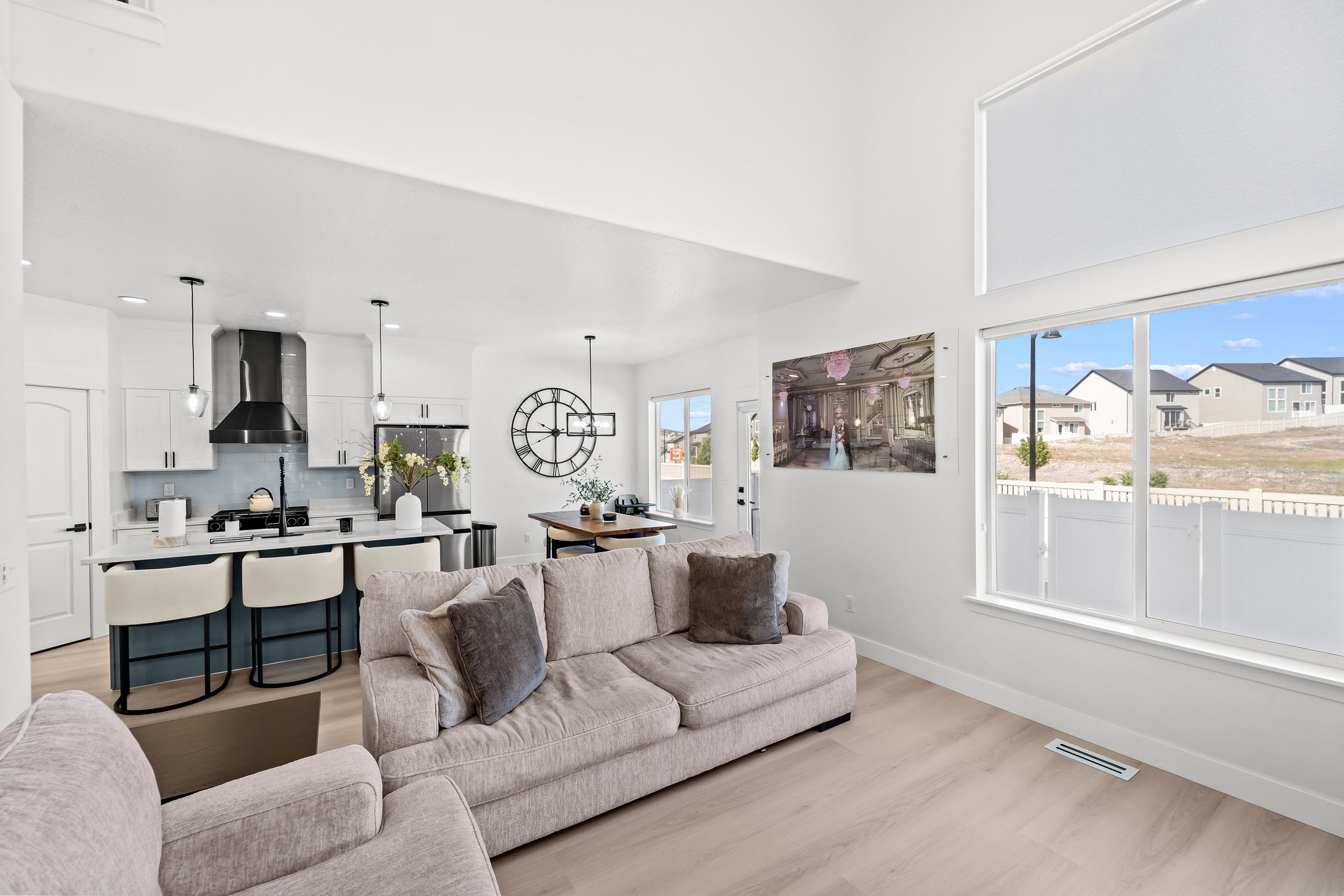 Vaulted ceilings illuminate an open concept living area featuring light wood-finish flooring