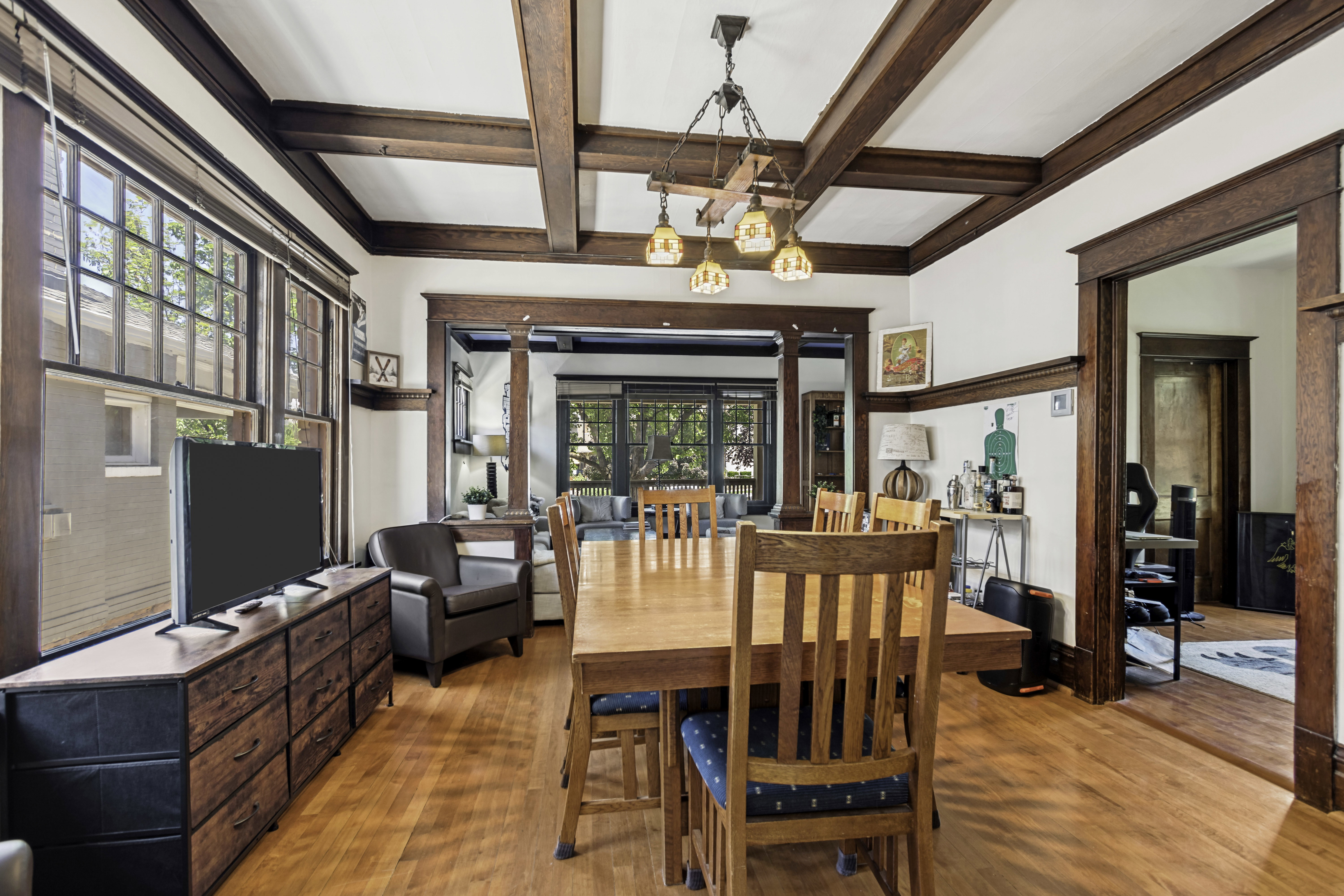 Hardwood flooring throughout featuring dark wood trim and beam ceiling details