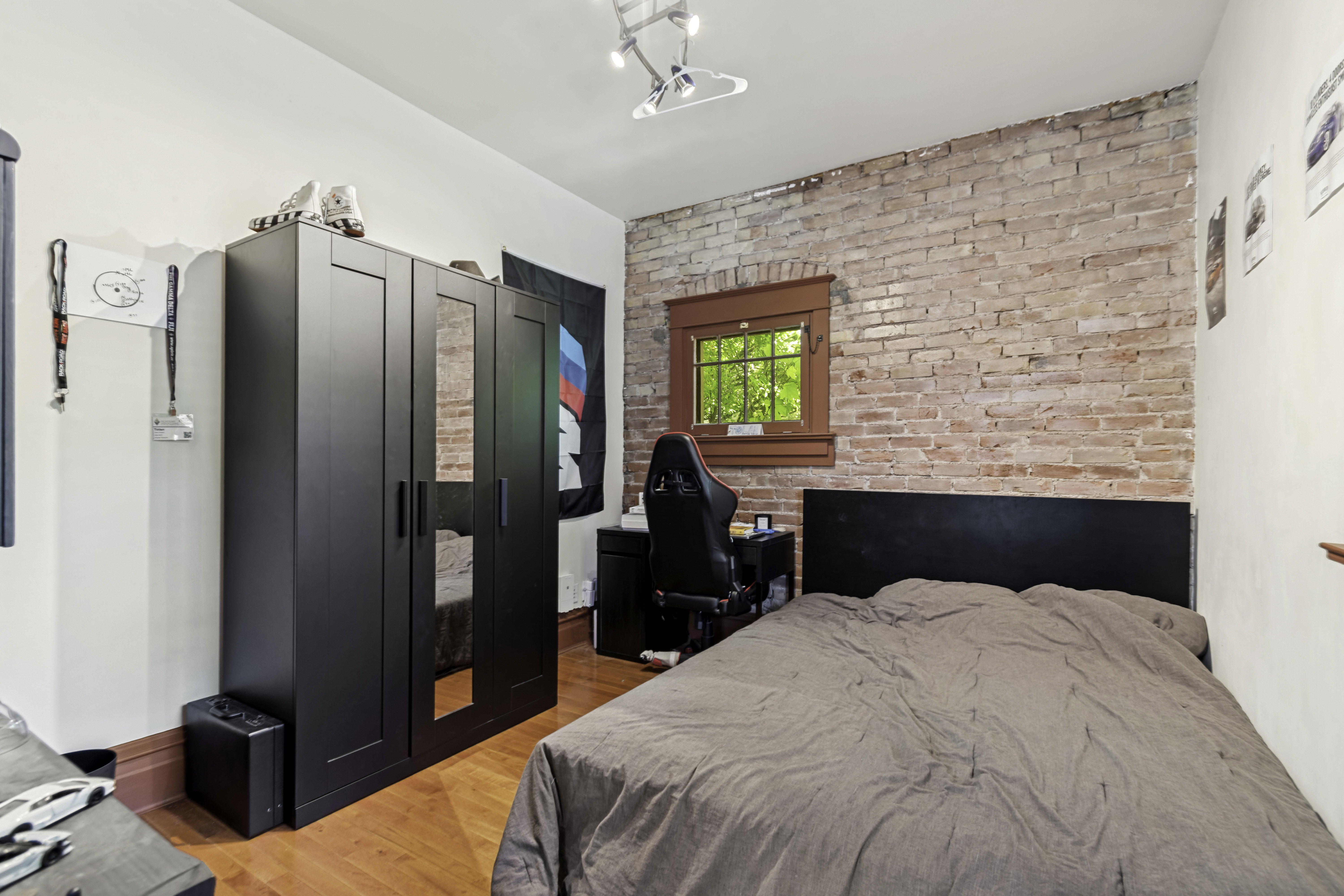 Exposed brick accent wall with a wood-trimmed window