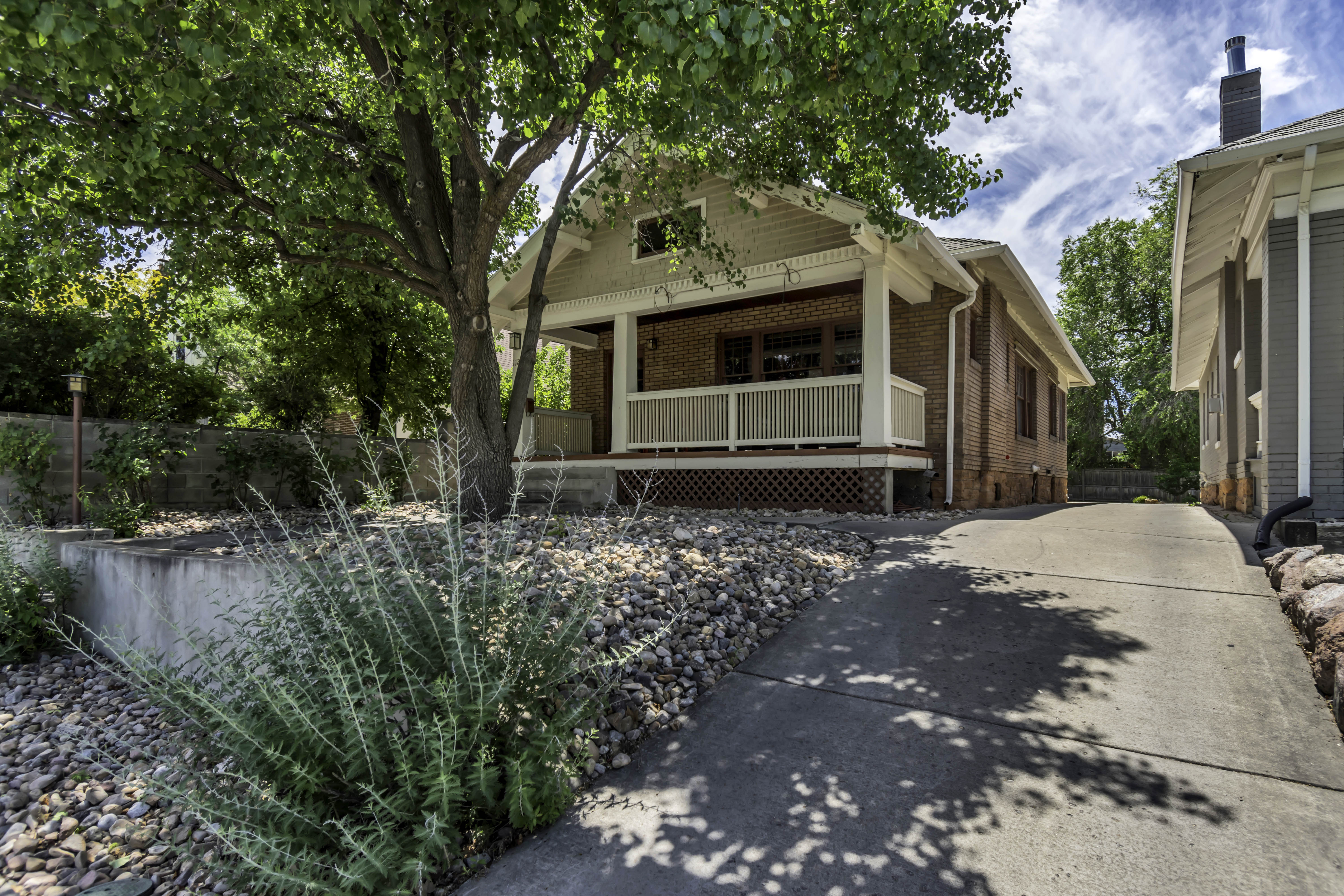 Brick exterior featuring a covered front porch with white railings and columns